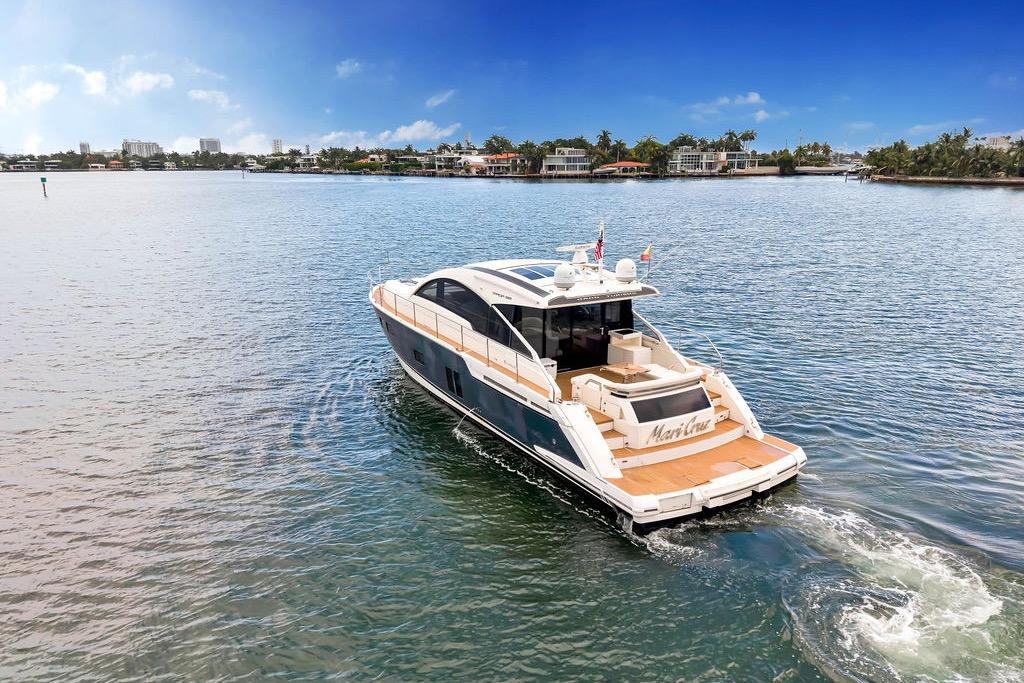 2012 Fairline Targa 58 yacht cruising on a serene waterway under a clear blue sky.