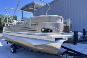 2012 Avalon Tahoe pontoon boat on trailer, parked near a building.