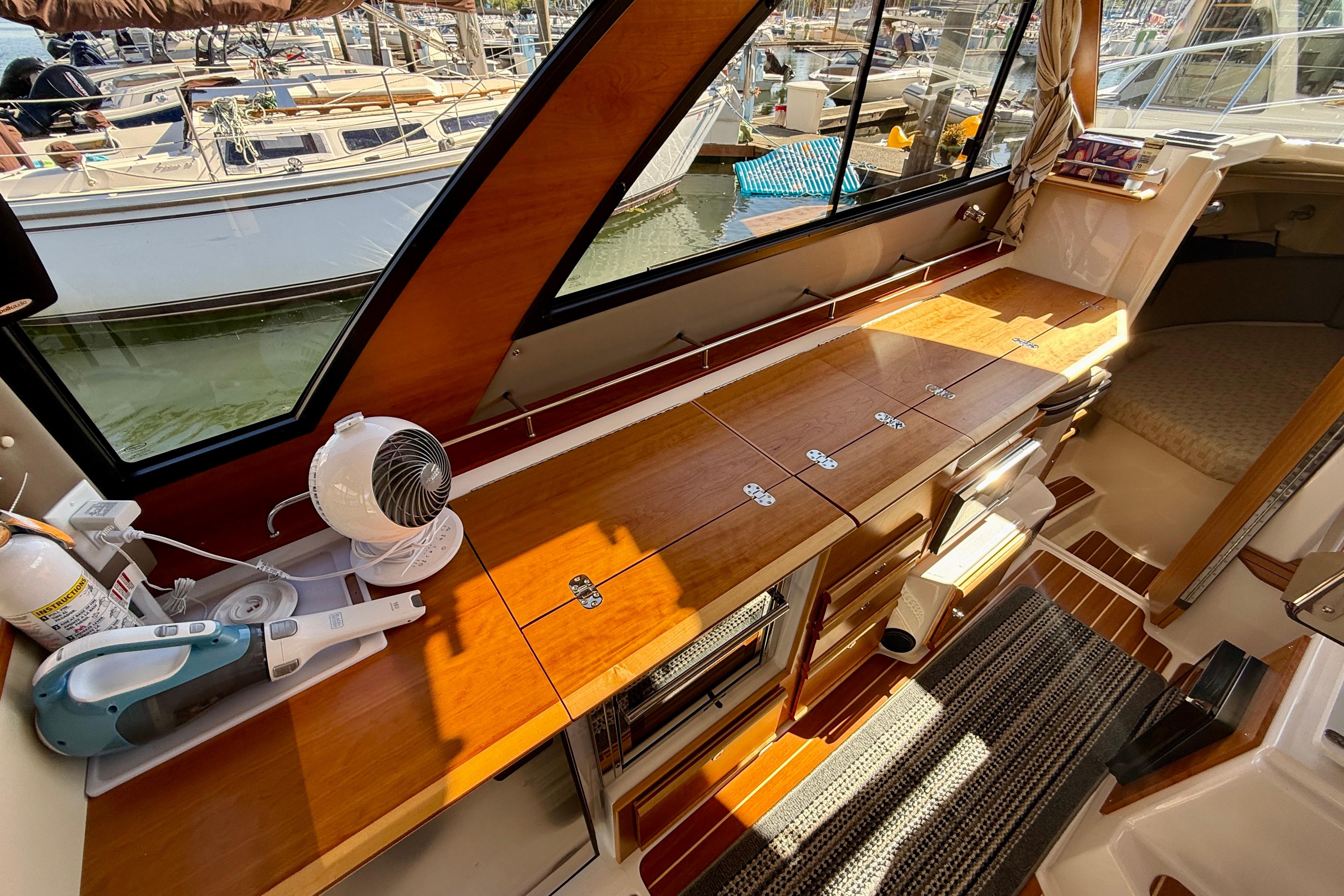 2023 Cutwater C-30 Sedan interior with wooden cabinetry and marina view.