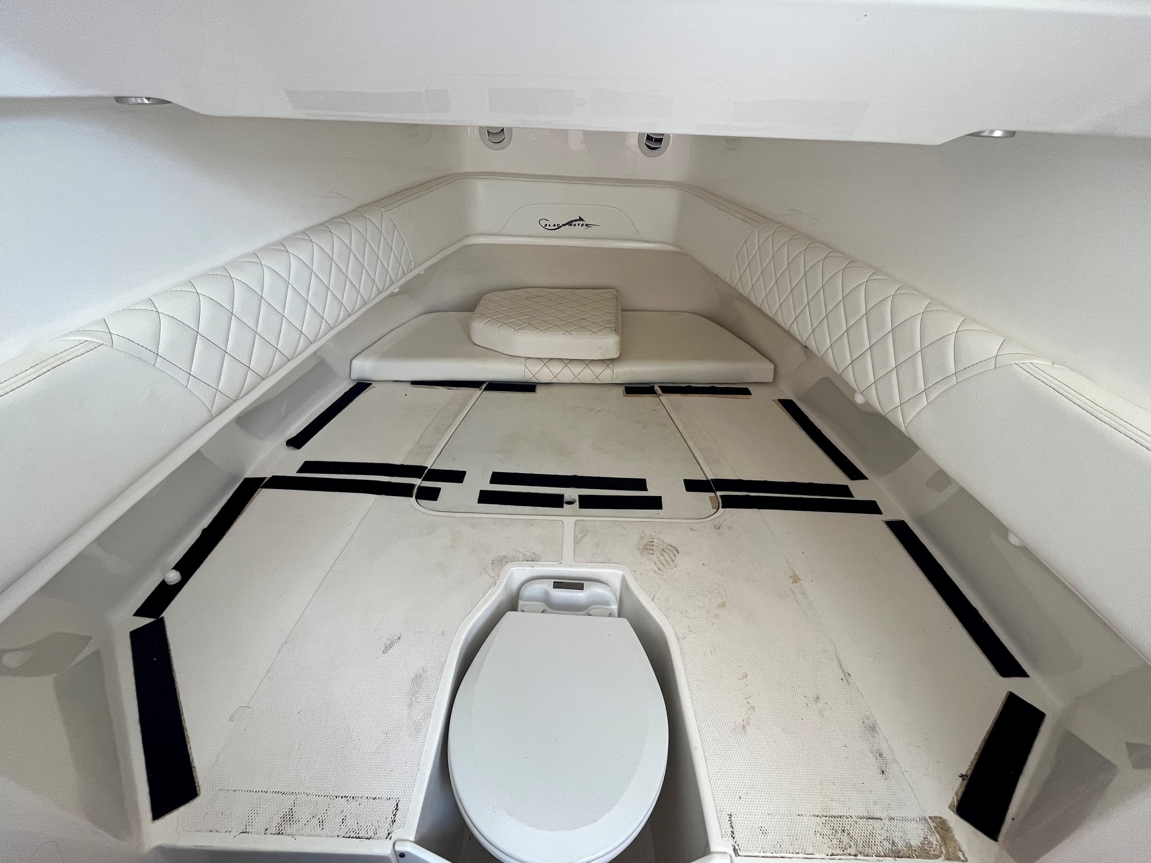 Interior cabin of 2018 Blackwater 43 boat with white seating and toilet.