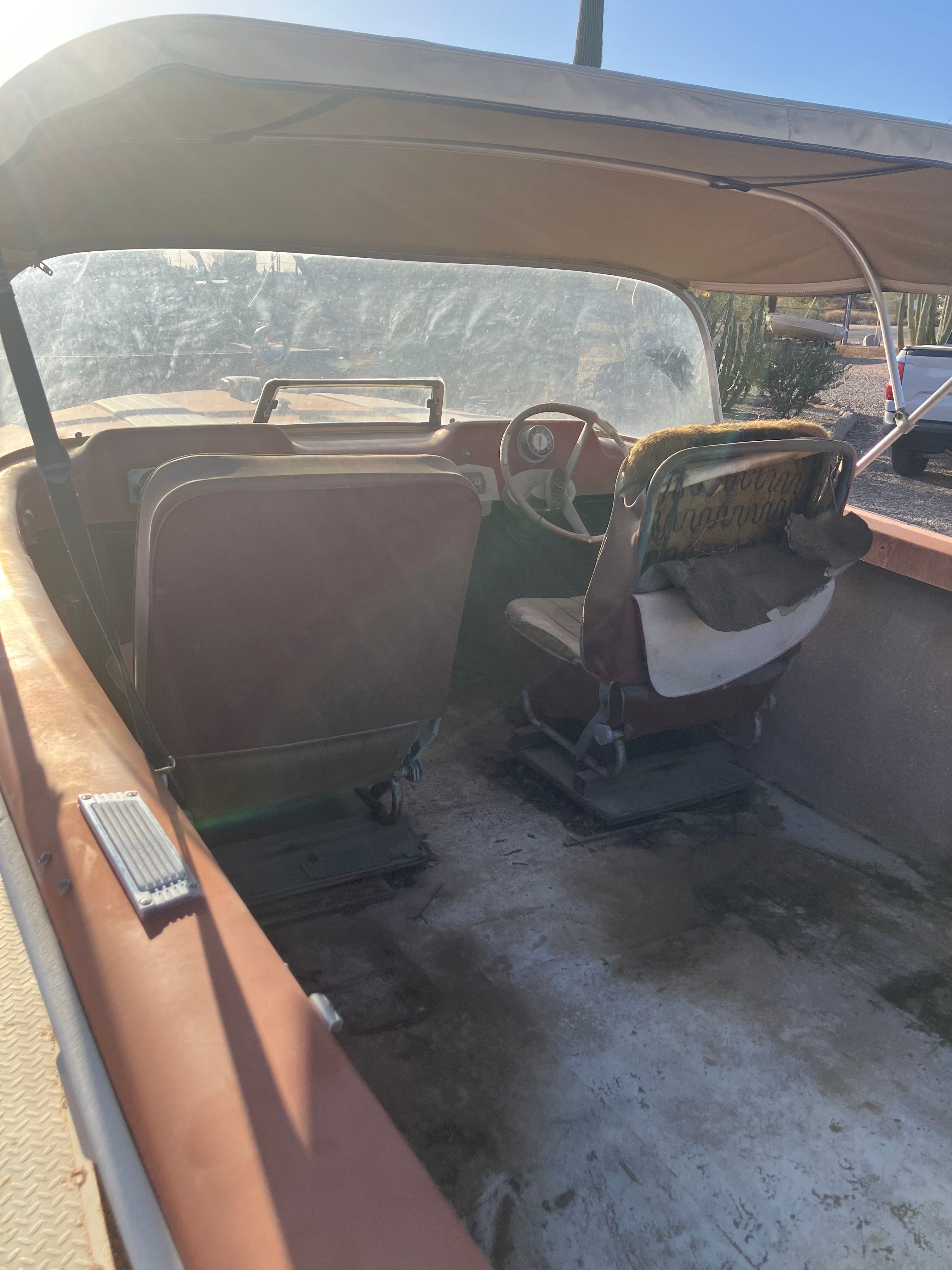 Interior view of a 1958 Hydroswift Runabout with worn seats and steering wheel.