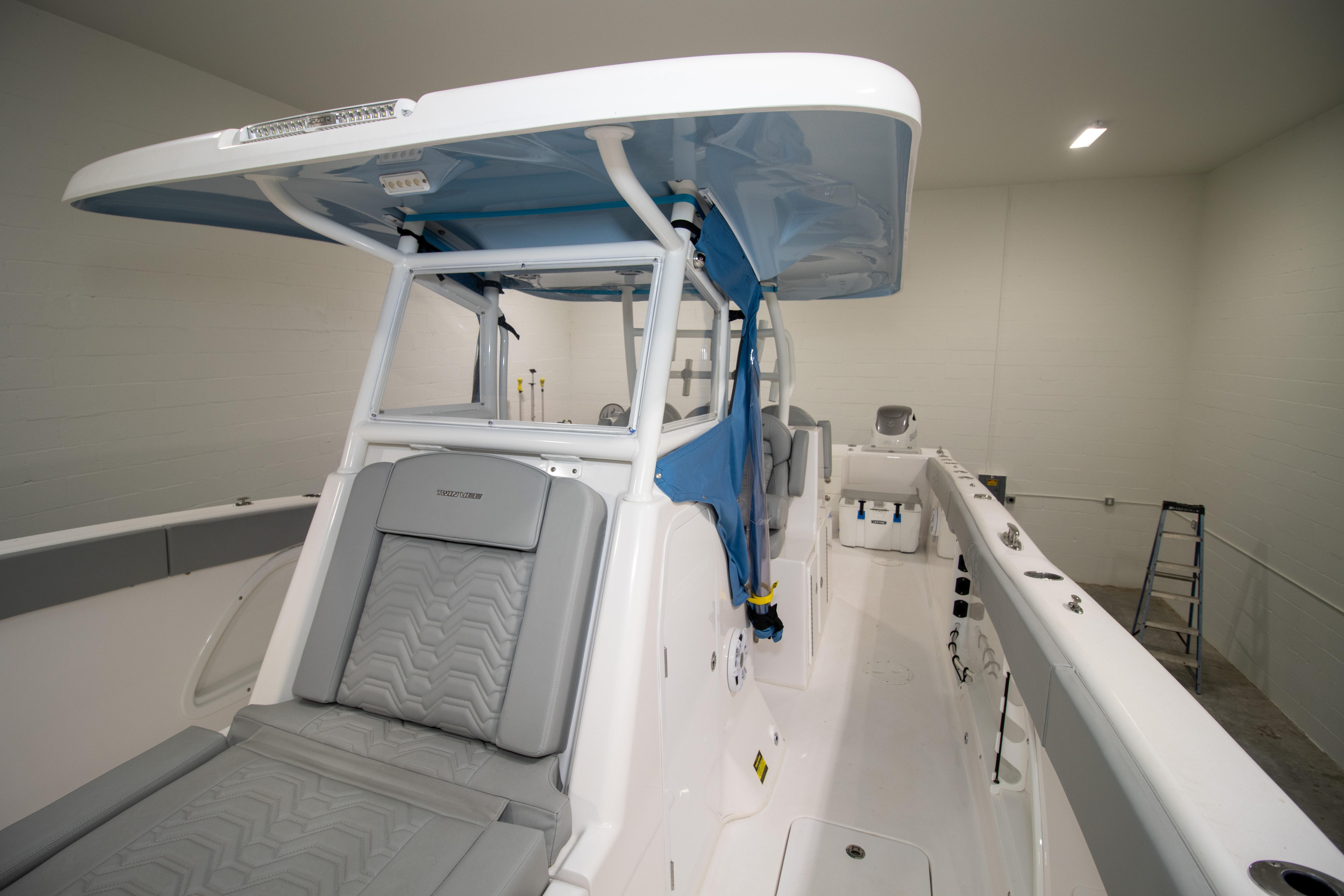 2023 Twin Vee 340 GFX CC boat interior with seating and canopy in a showroom.
