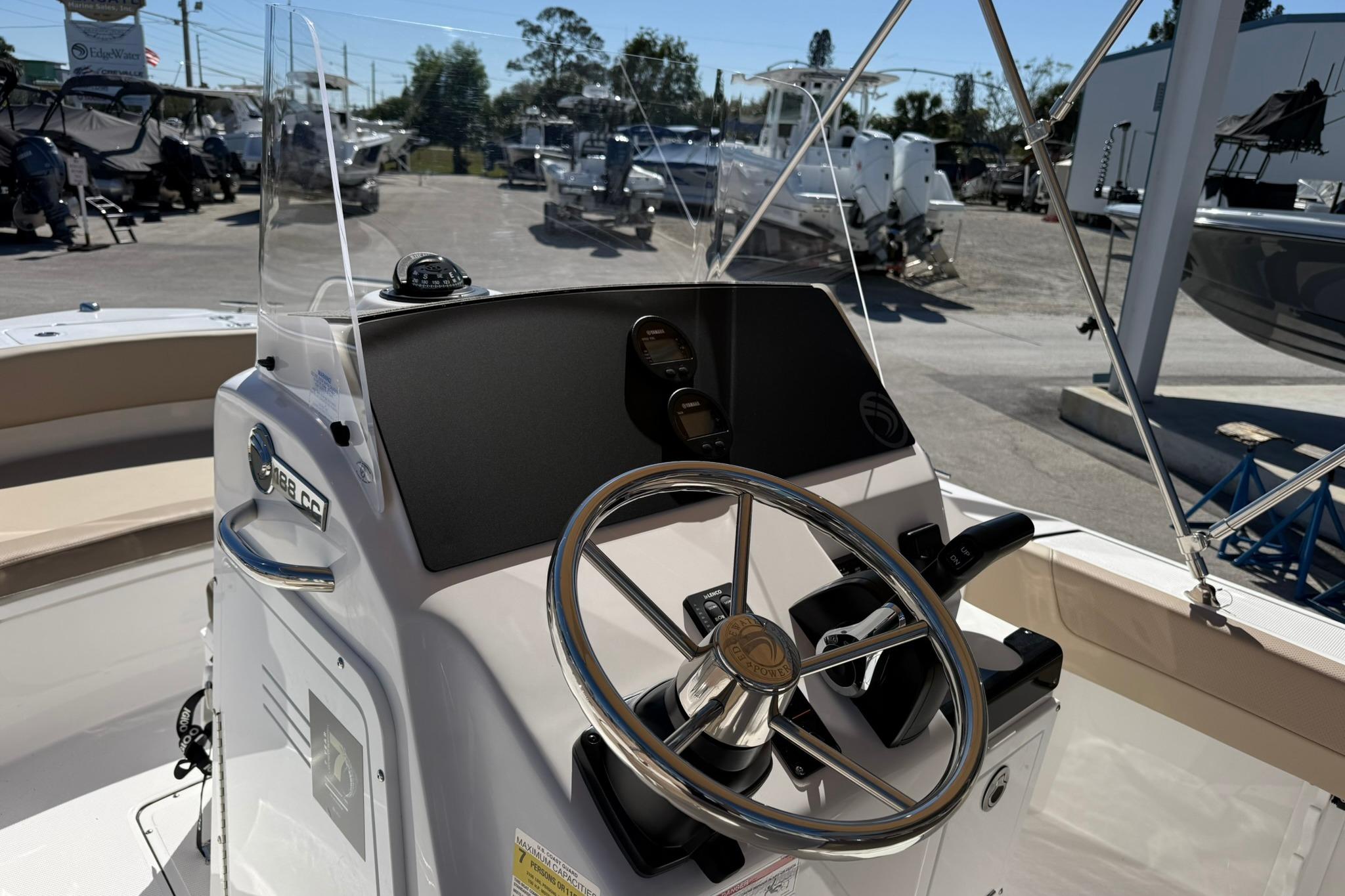 2026 Edgewater 188CC boat console with steering wheel and controls in a marina setting.