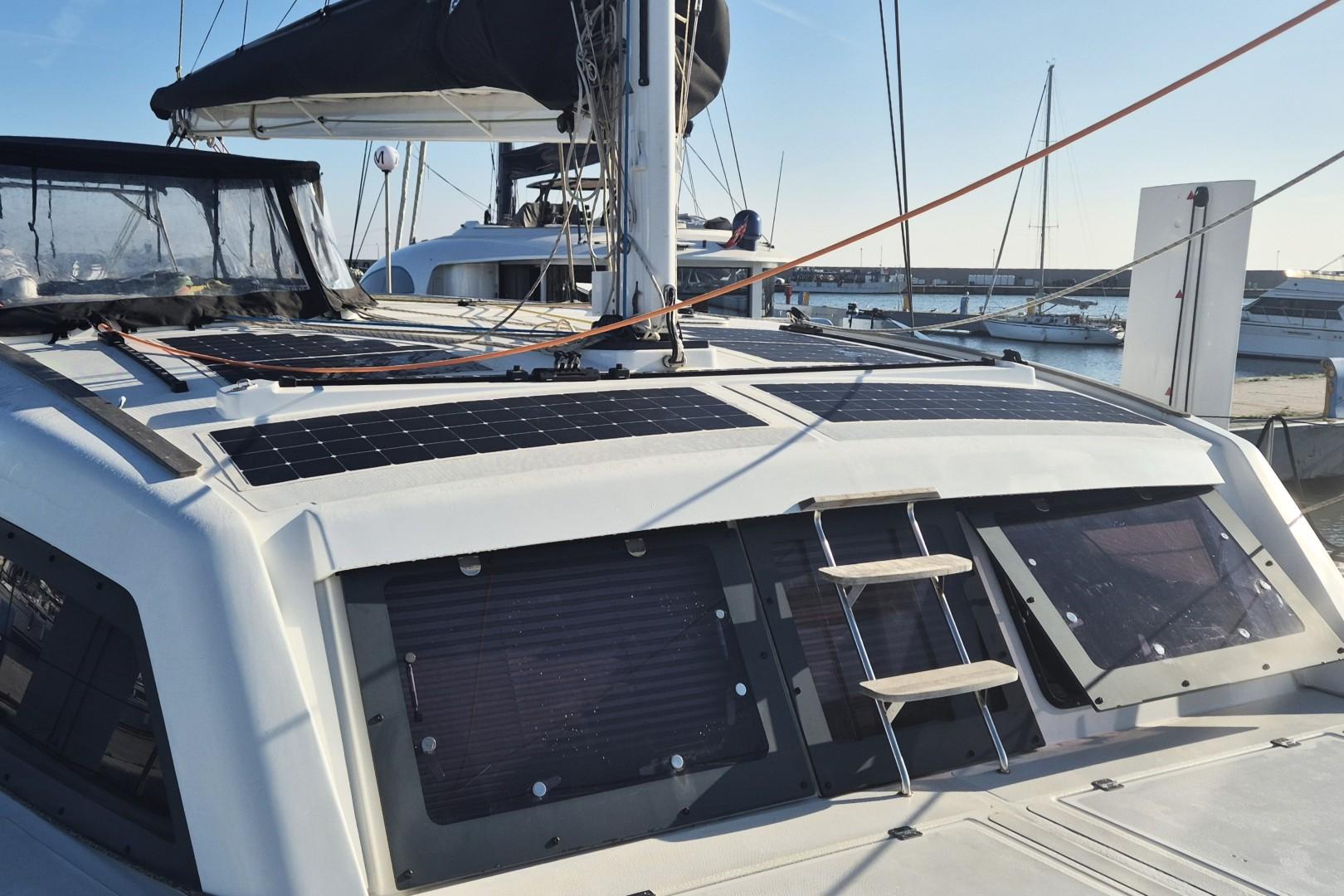 2023 Catana Ocean Class yacht with solar panels, docked in a marina.