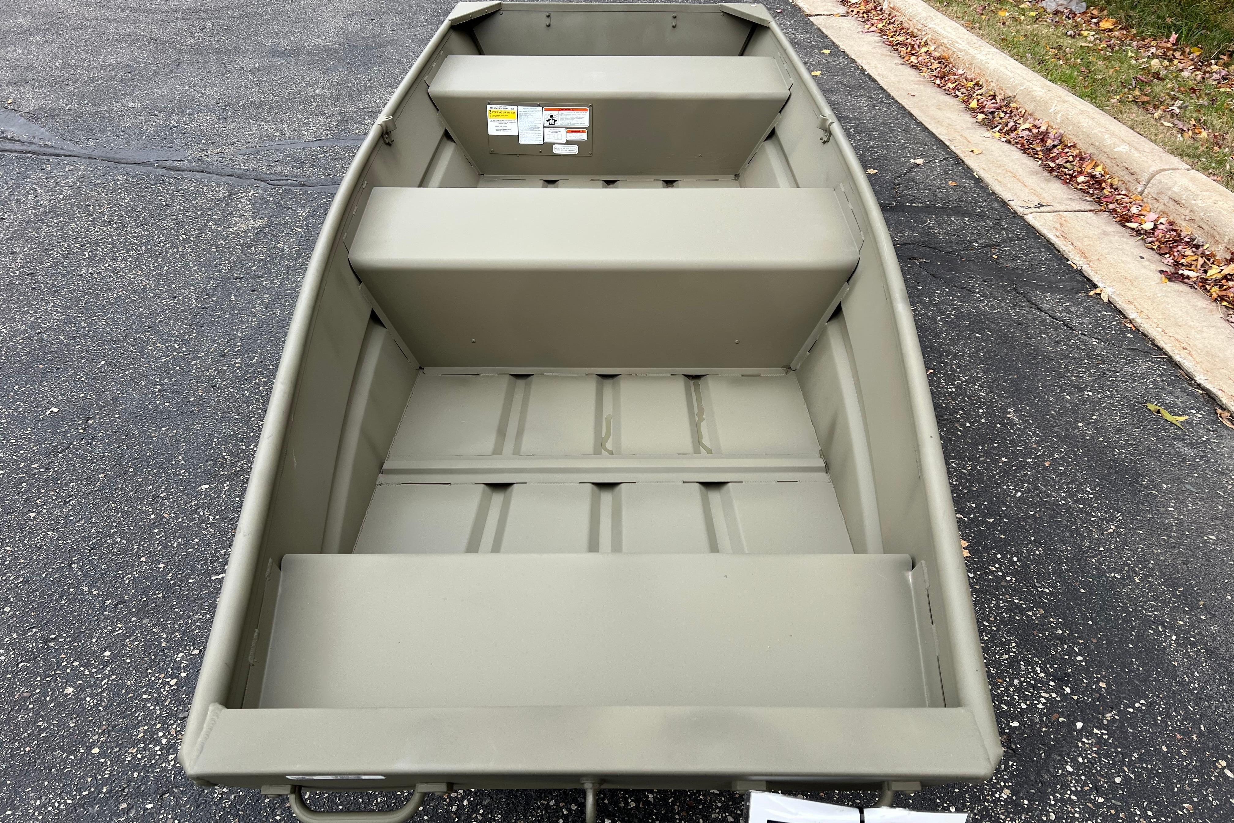 2026 Tracker Grizzly 12 Jon boat on pavement, showcasing interior seating and design.