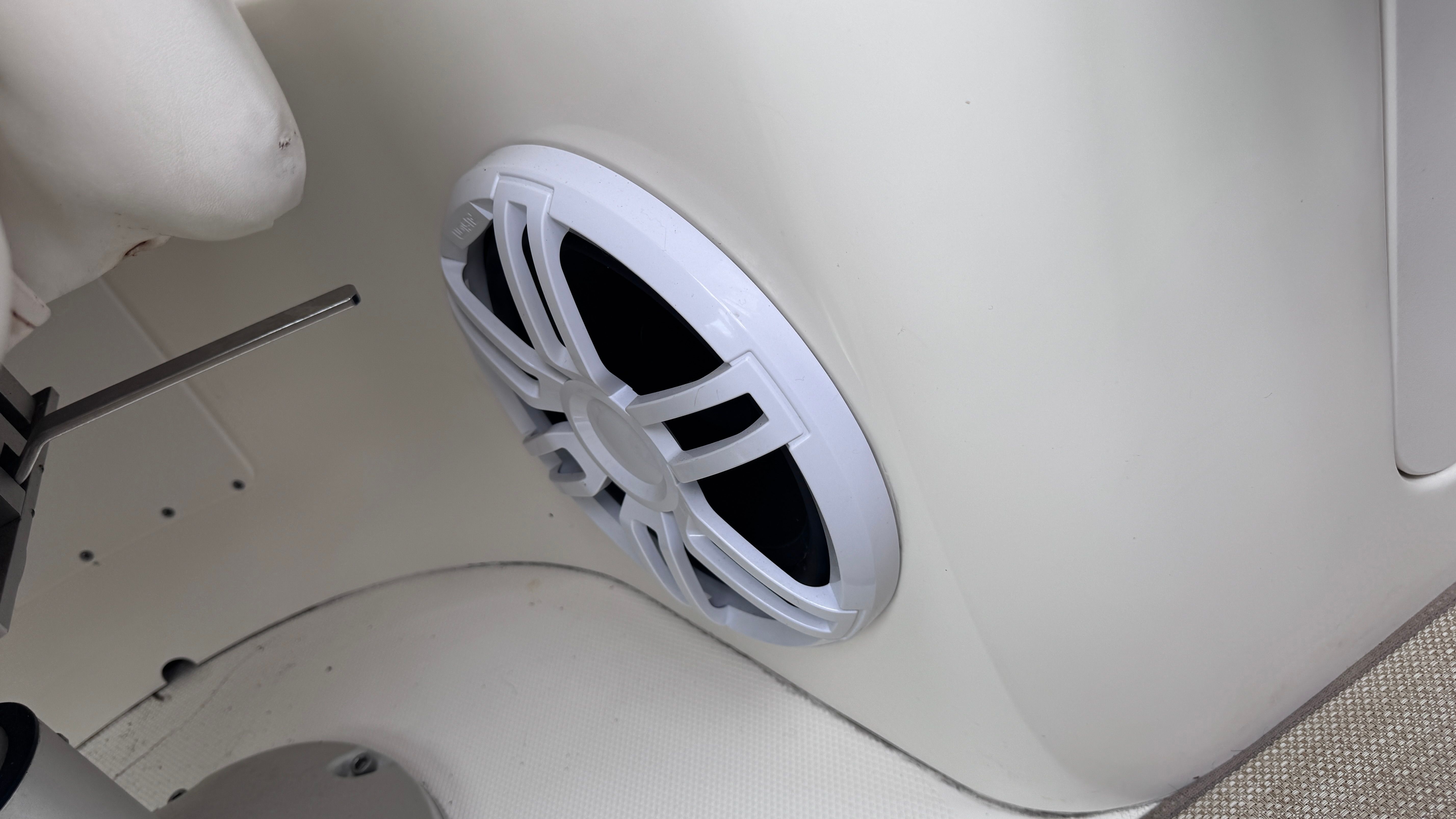 Close-up of a speaker on a boat, mounted in a white wall.