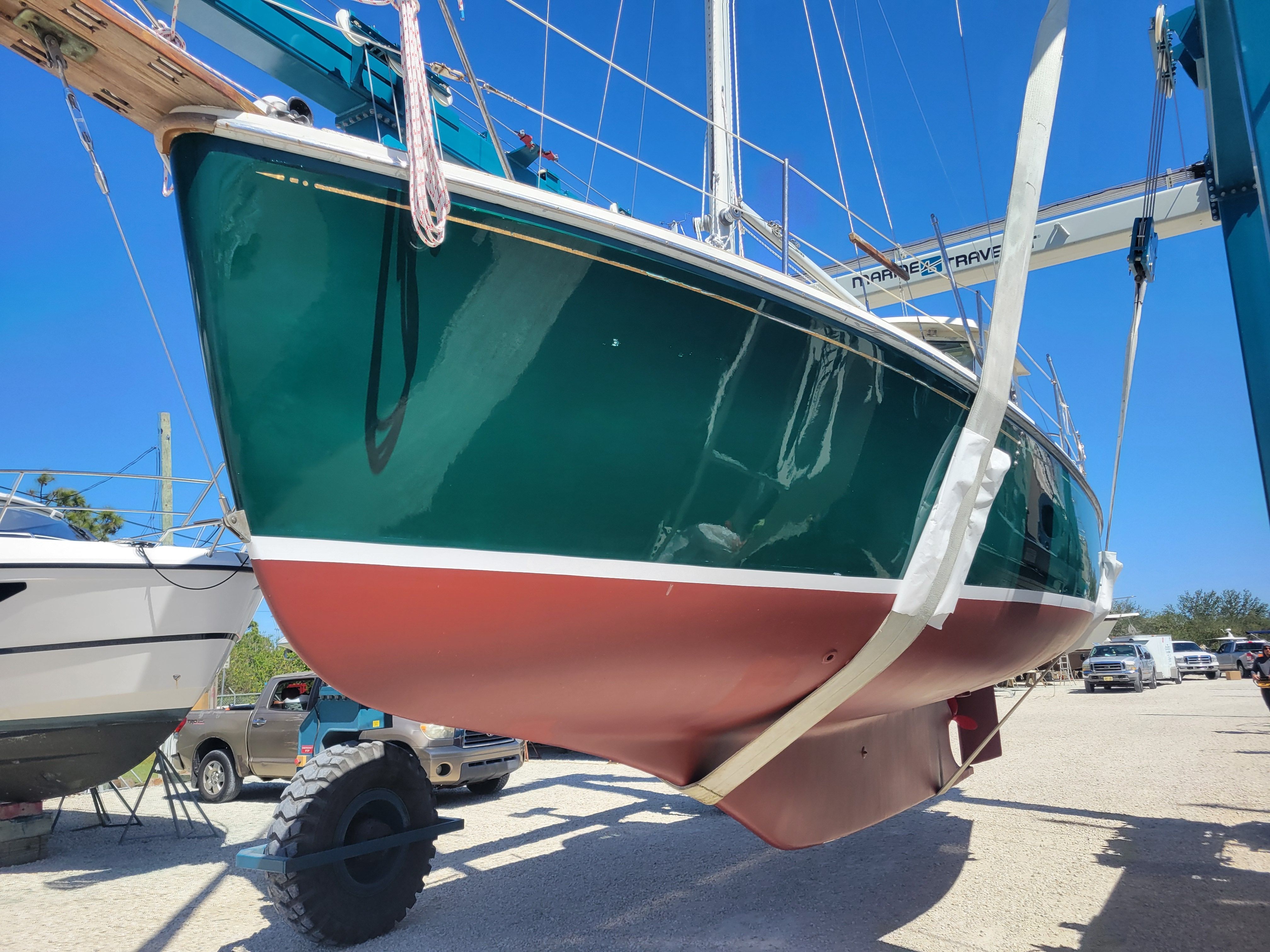 A 1989 Cape Dory MS300 sailboat being lifted out of the water by a crane.