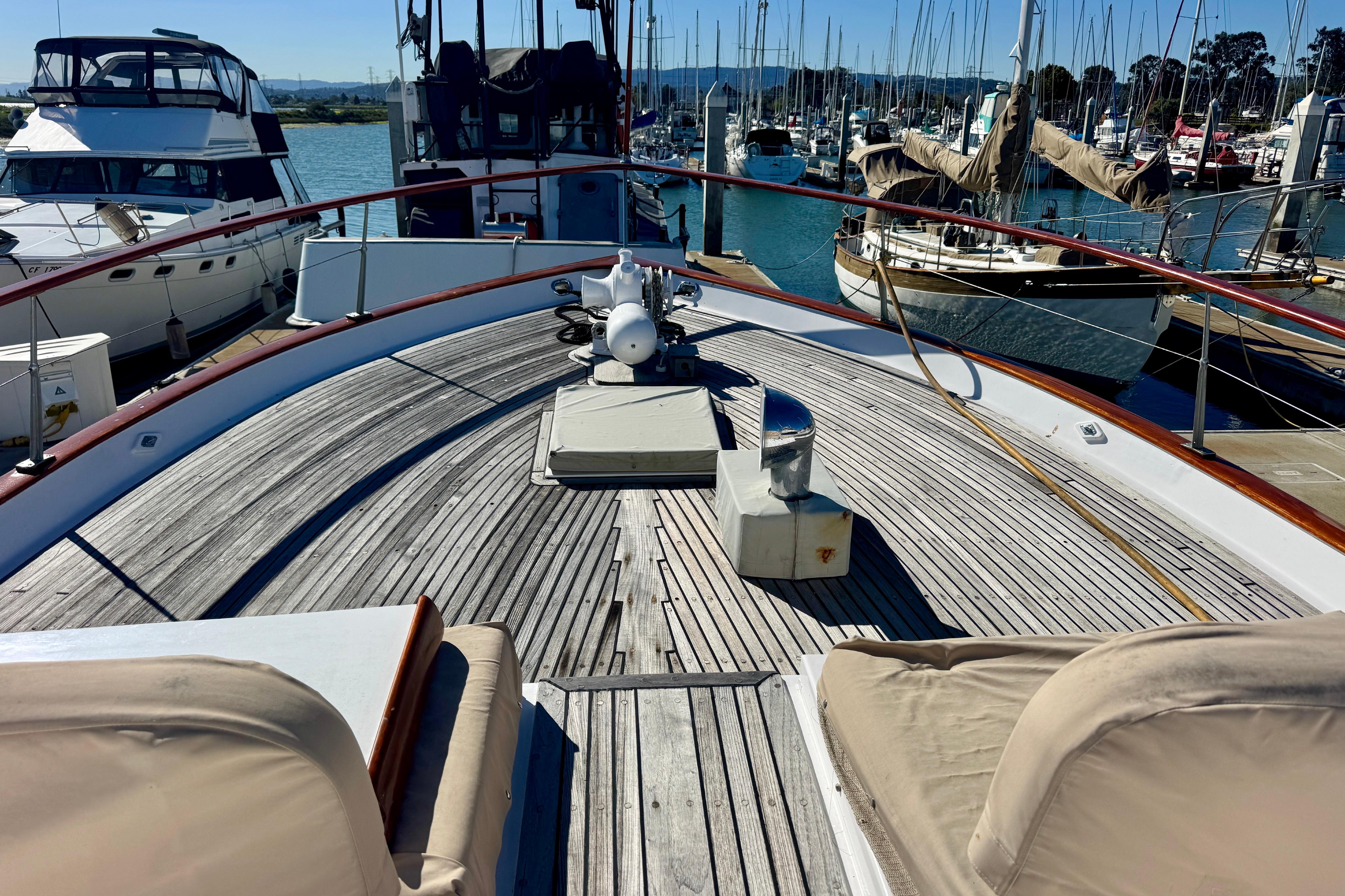 1958 Blanchard Pilothouse yacht deck with wooden flooring, docked at a marina.