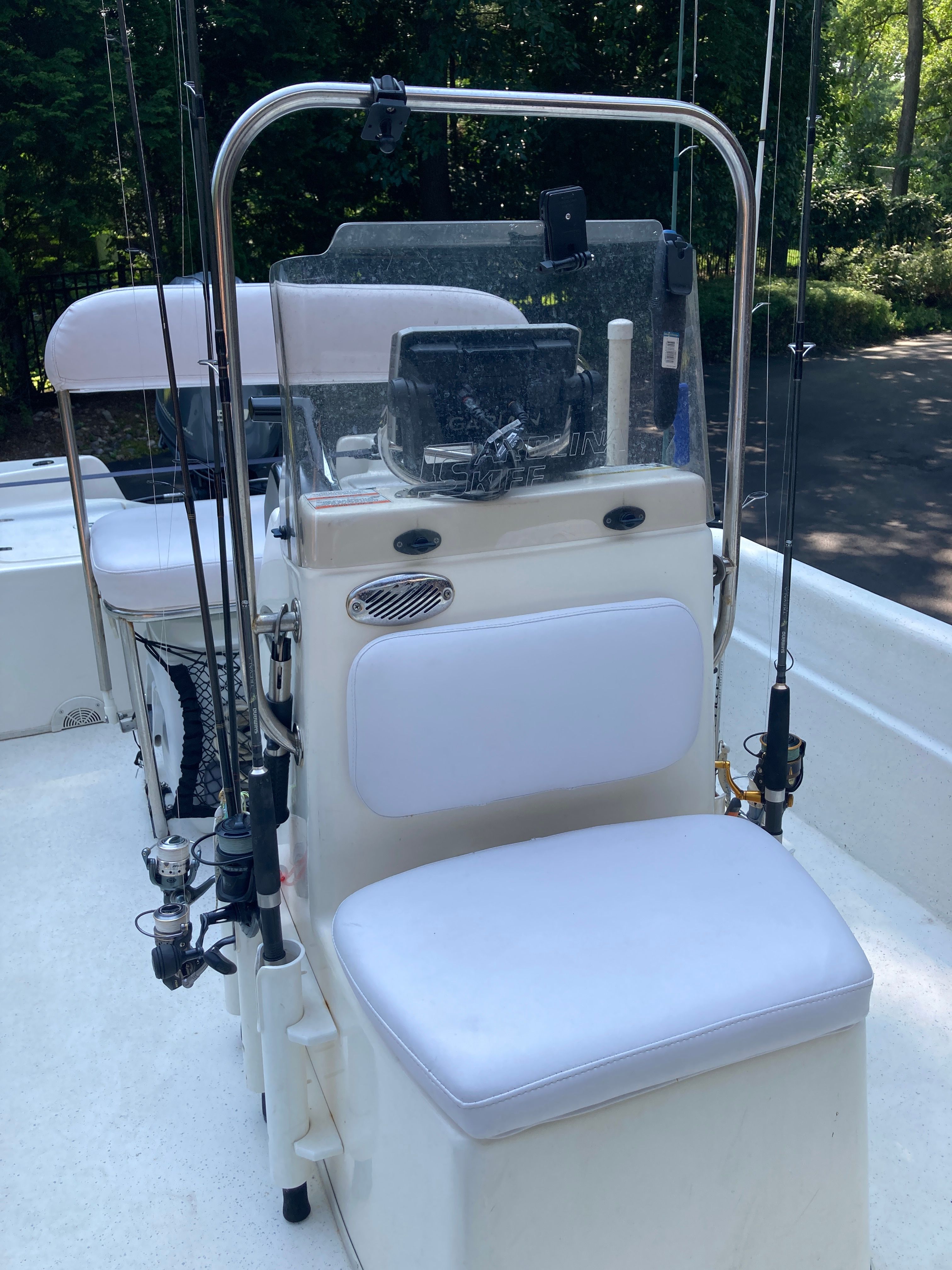 The image shows the cockpit of a 2012 Carolina Skiff JVX16CC with fishing rods.