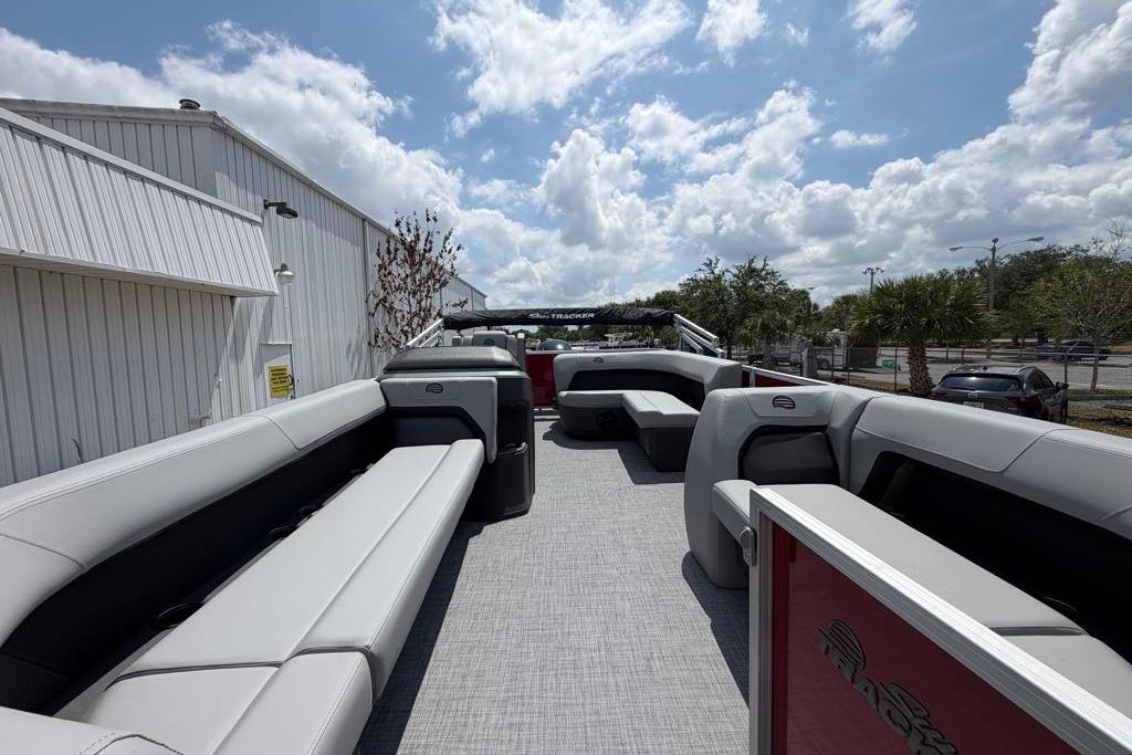 2026 Sun Tracker Party Barge 18 DLX pontoon boat with spacious seating under a cloudy sky.