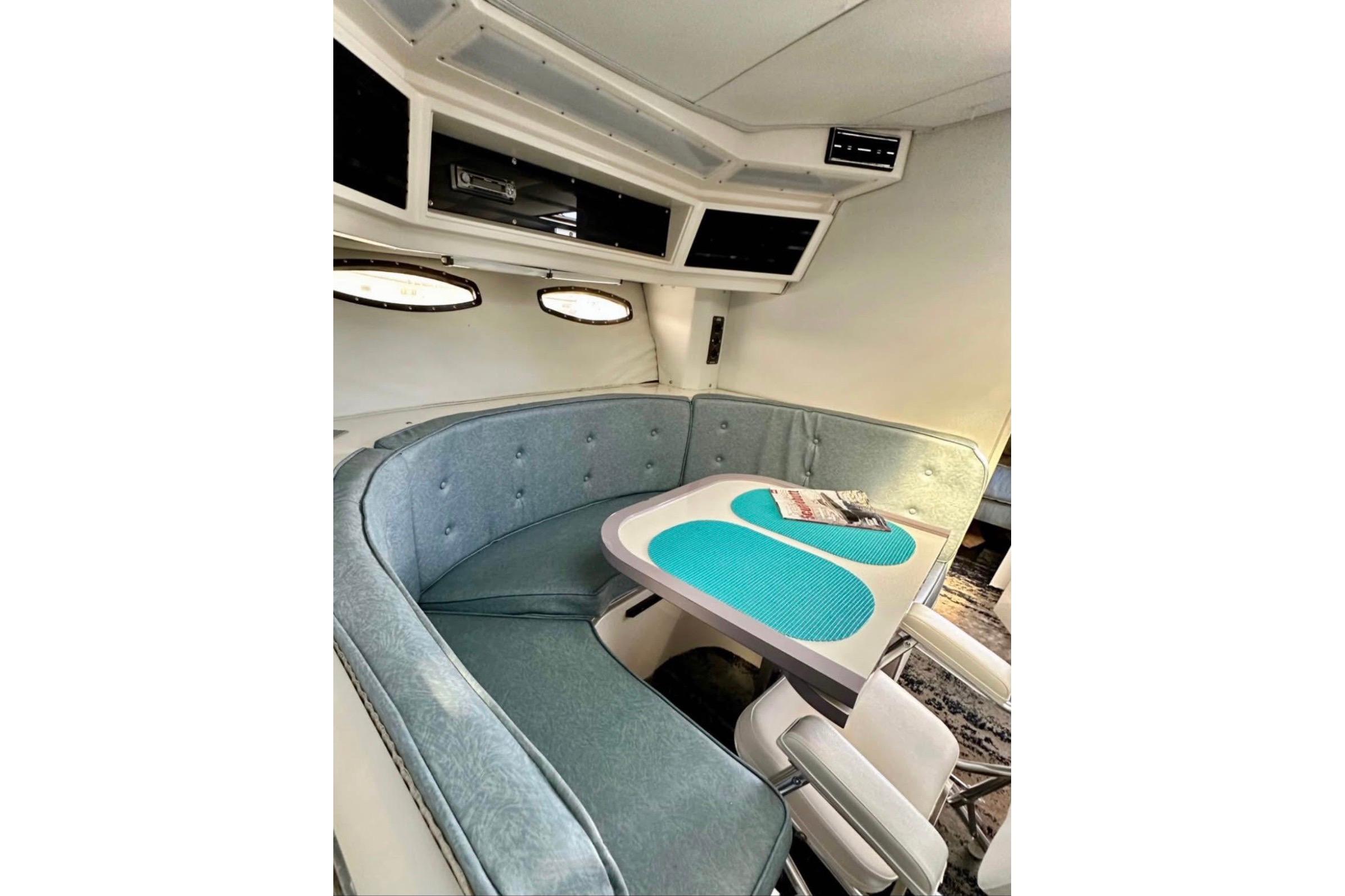 1987 Wellcraft 3400 Gran Sport interior with teal seating and table.