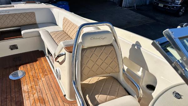 2014 Chris-Craft 28 LAUNCH boat interior with beige diamond-stitched seats and wooden flooring.