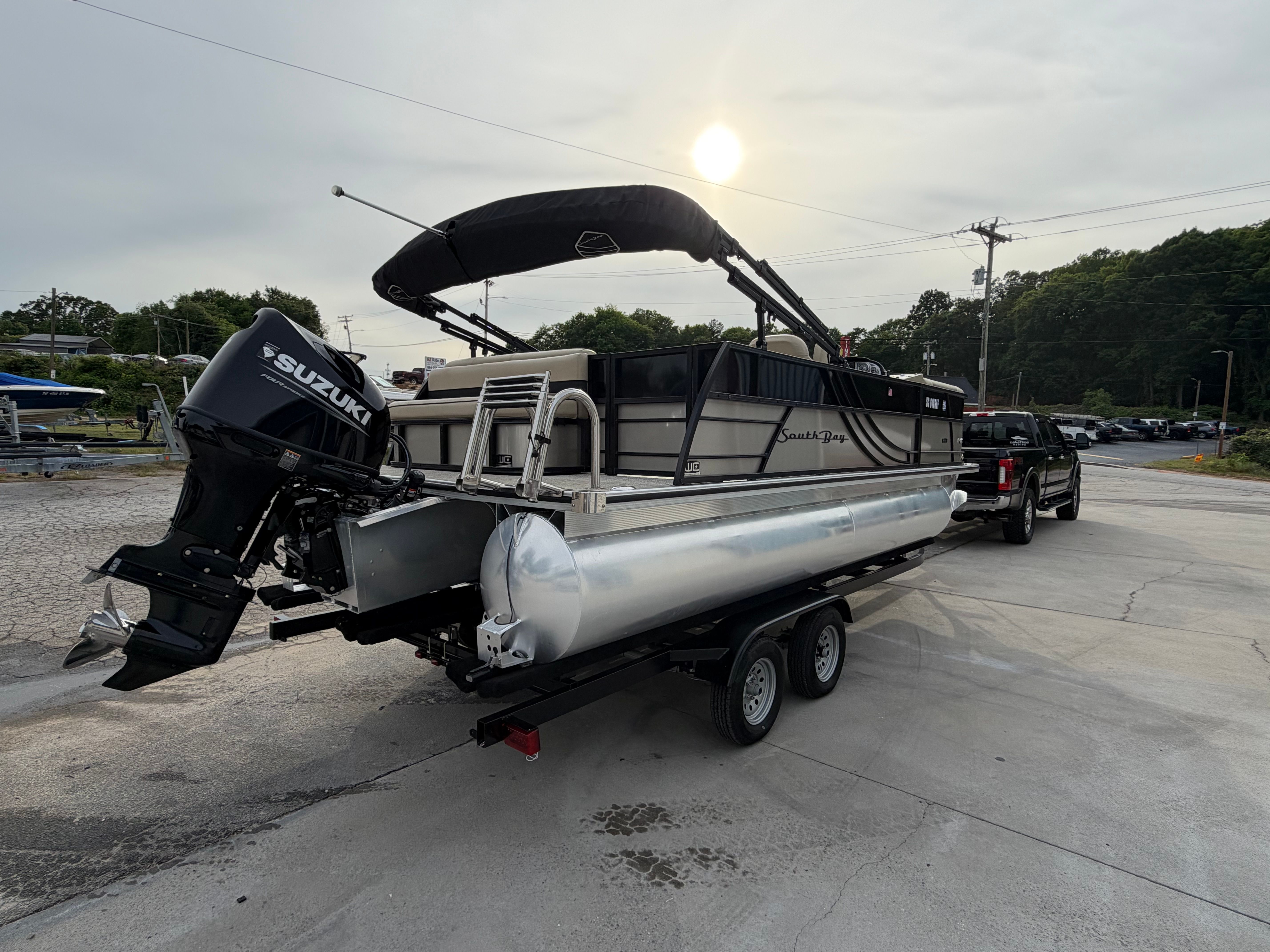 2023 South Bay S222 CR2 pontoon boat on trailer with Suzuki engine.