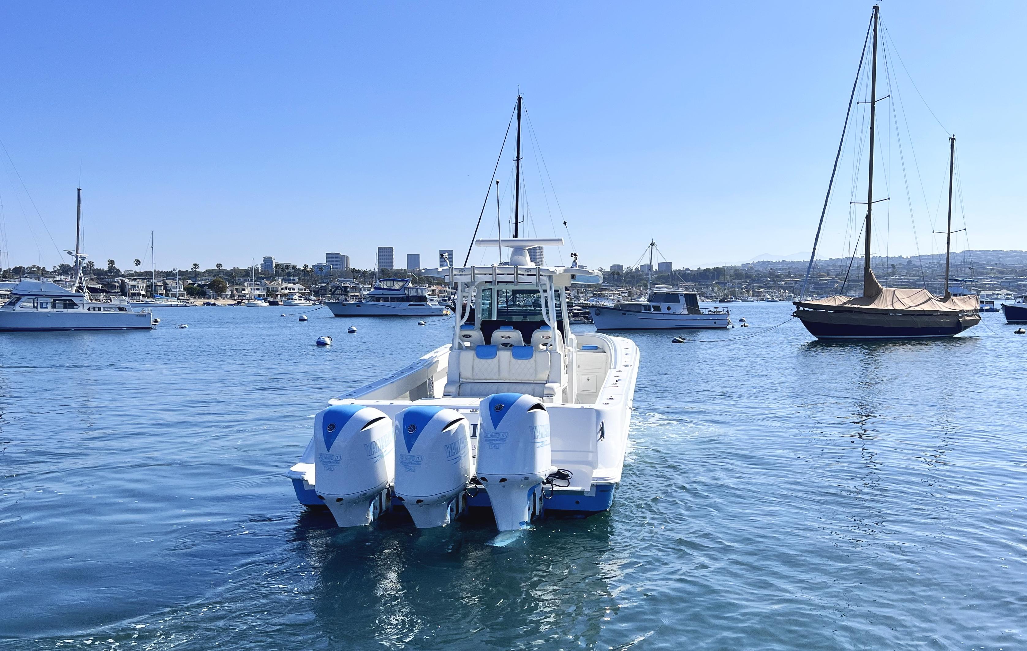 2018 HCB 39 Speciale boat with triple engines on a sunny harbor.