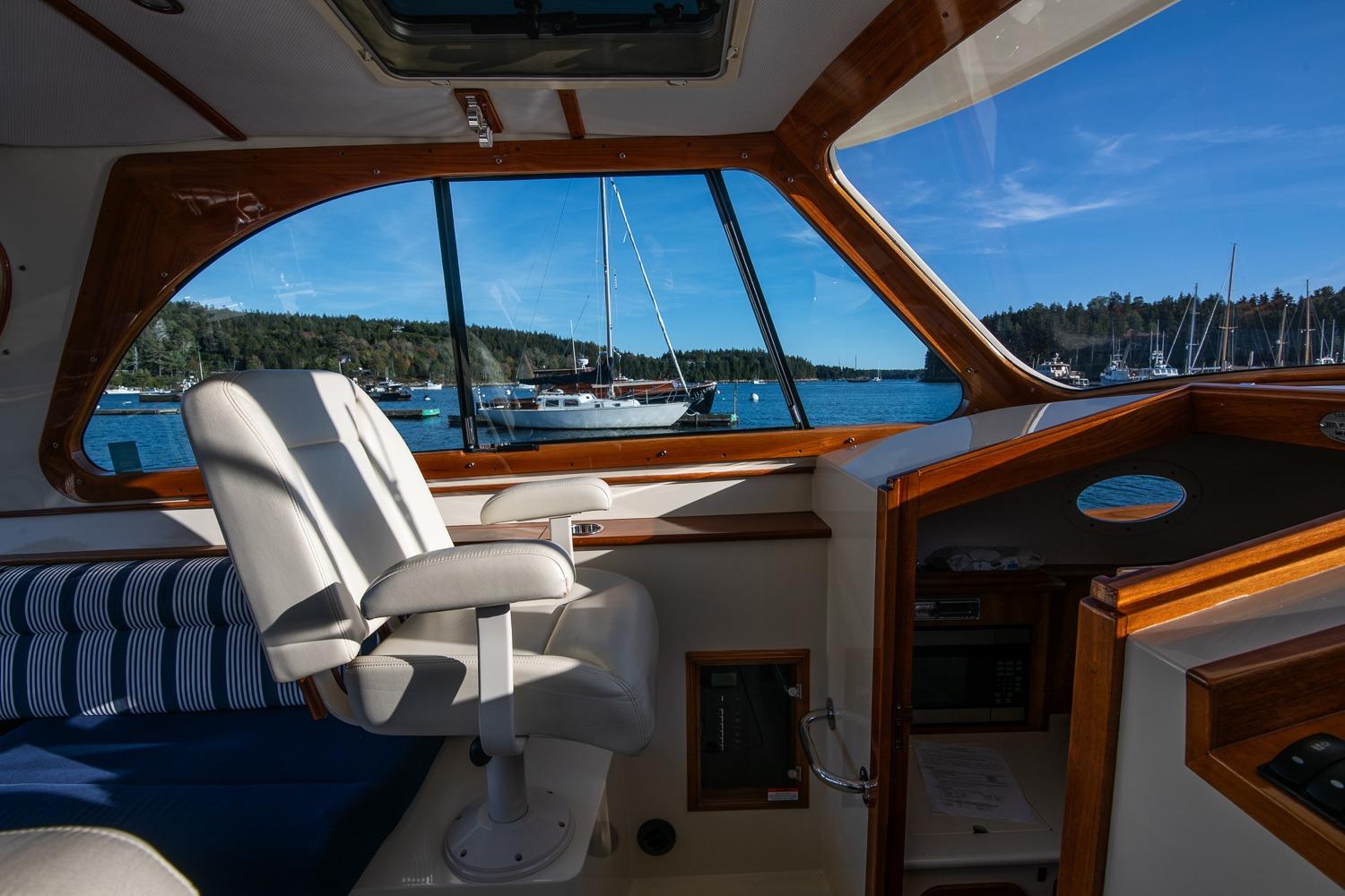 Interior view of 2013 Hinckley Talaria 34 yacht with scenic harbor backdrop.