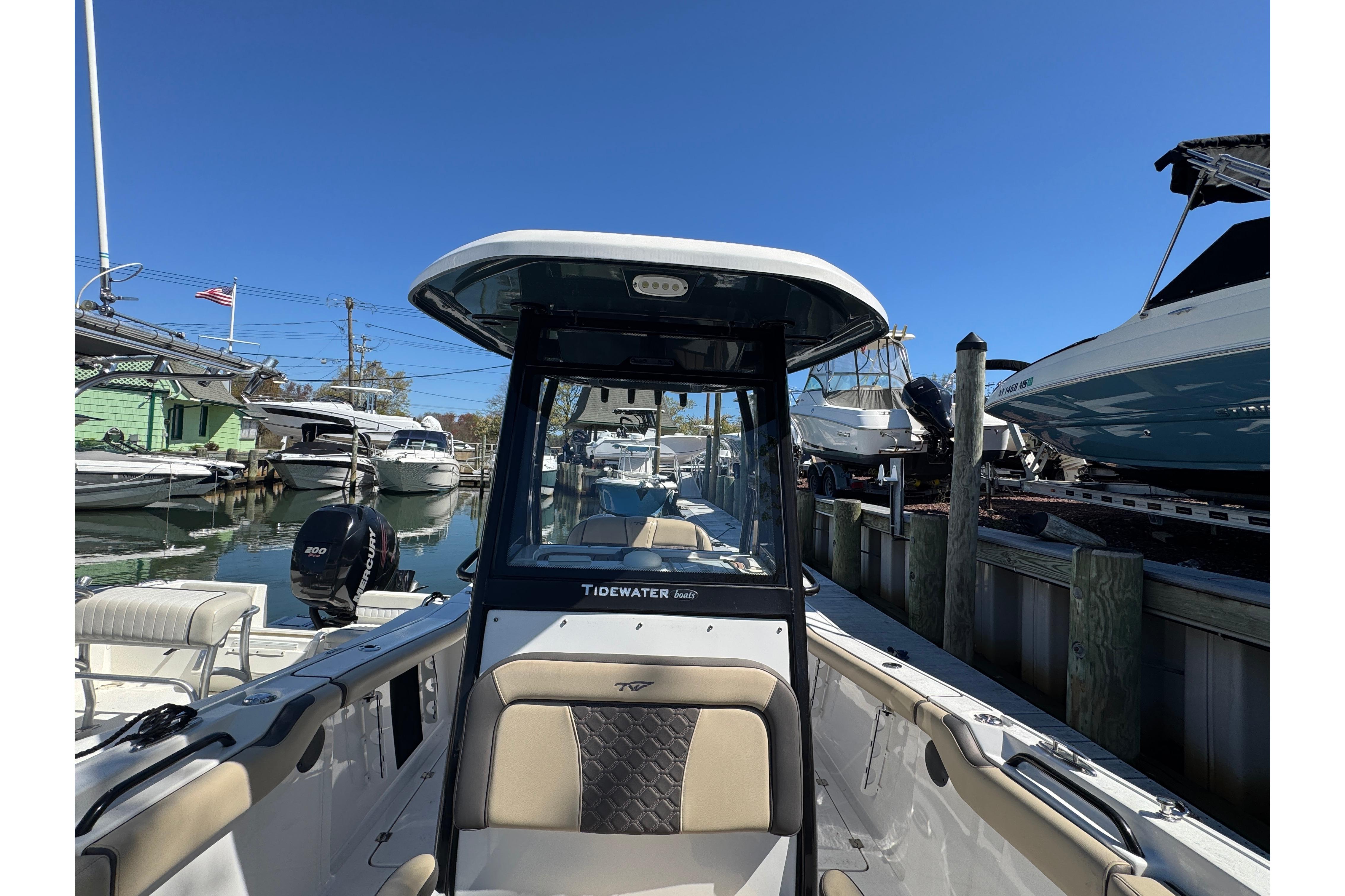 2022 Tidewater 256 CC Adventure boat docked in a marina under clear blue skies.