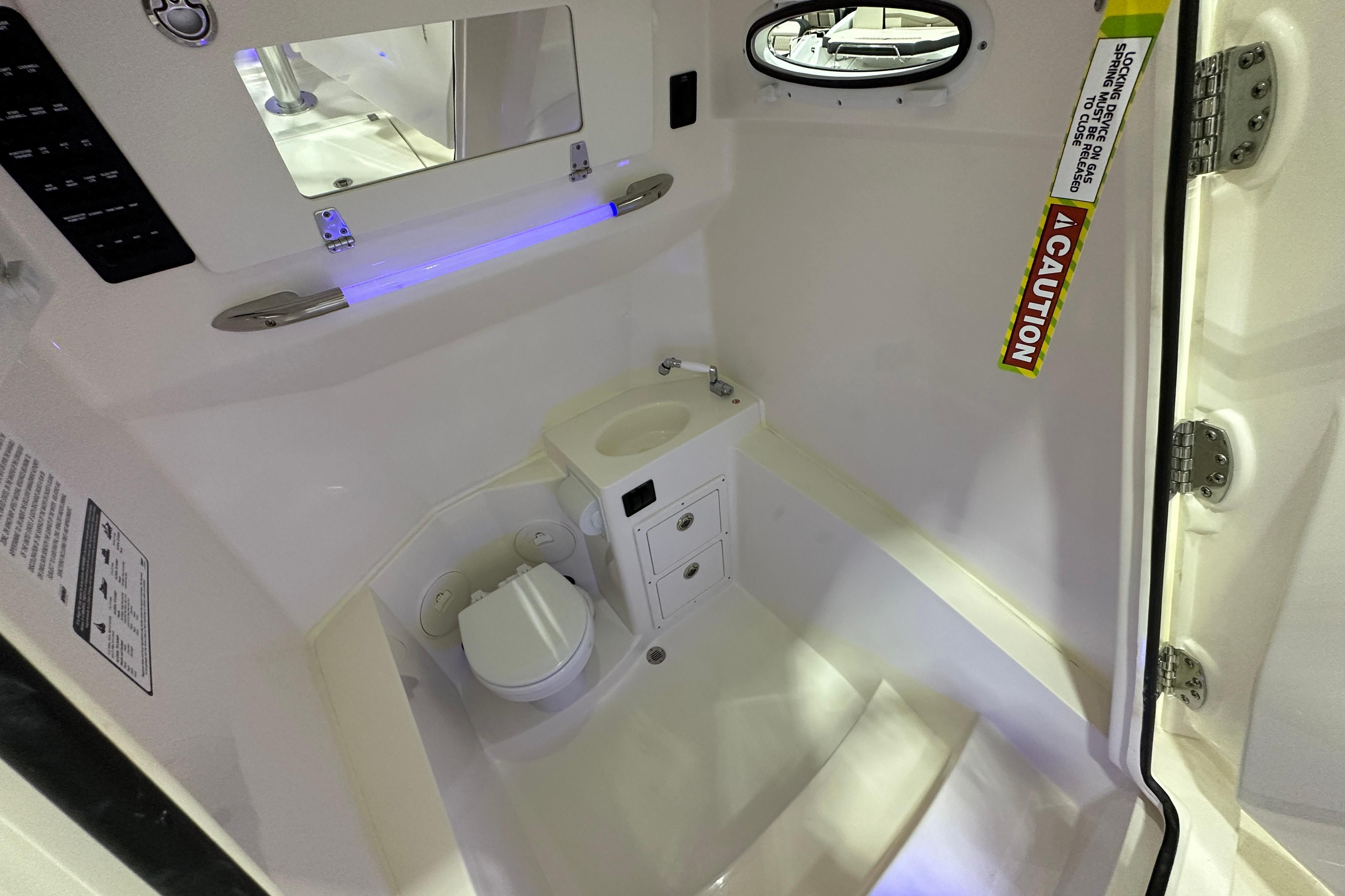 2024 Cobia 301 Center Console interior cabin with toilet and sink.