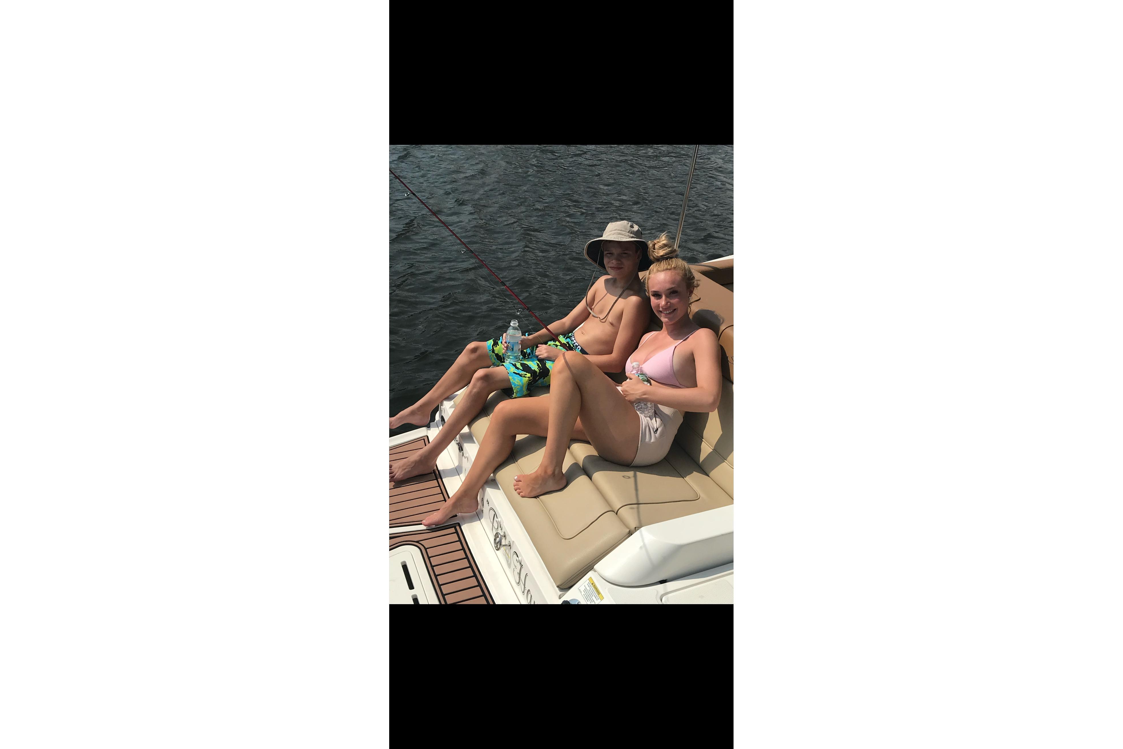 Two people relaxing on a 2014 Sea Ray 260 Sundeck boat.
