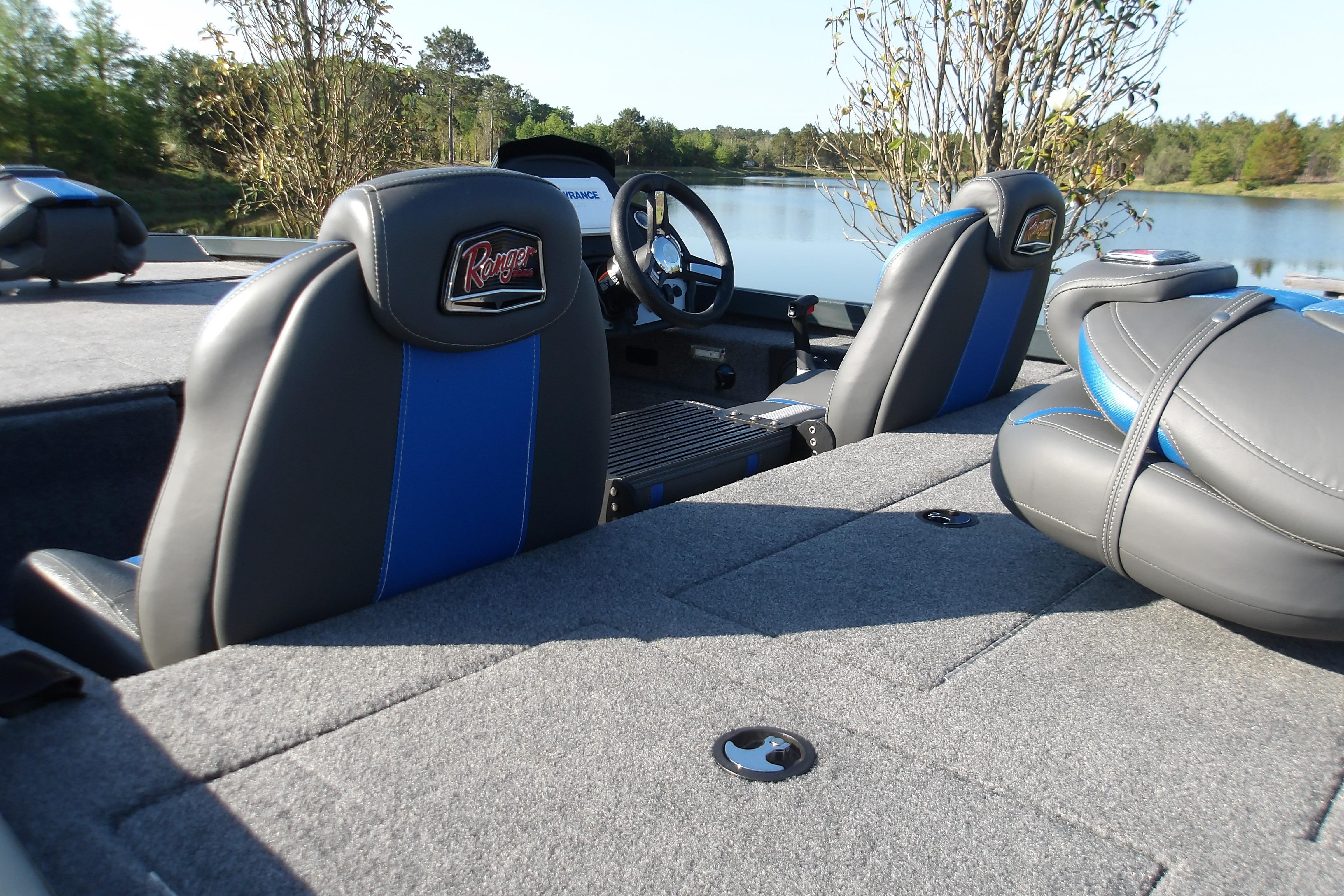 2024 Ranger RT188P boat interior with gray and blue seating by a lake.