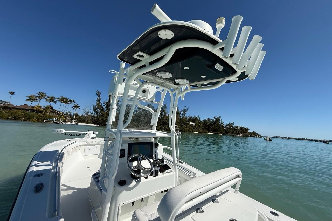 2017 Yellowfin 26 Hybrid boat on calm water with clear blue sky.