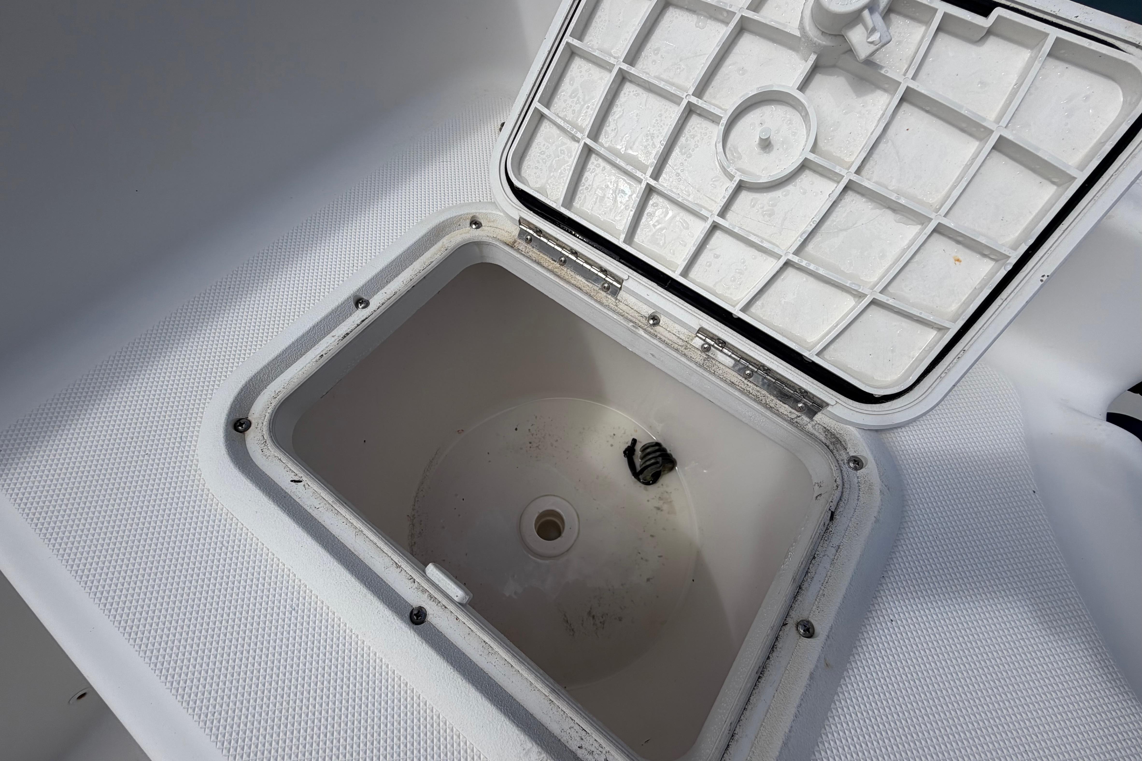 Open storage compartment on 2017 Release 196 RX boat, featuring a textured lid.