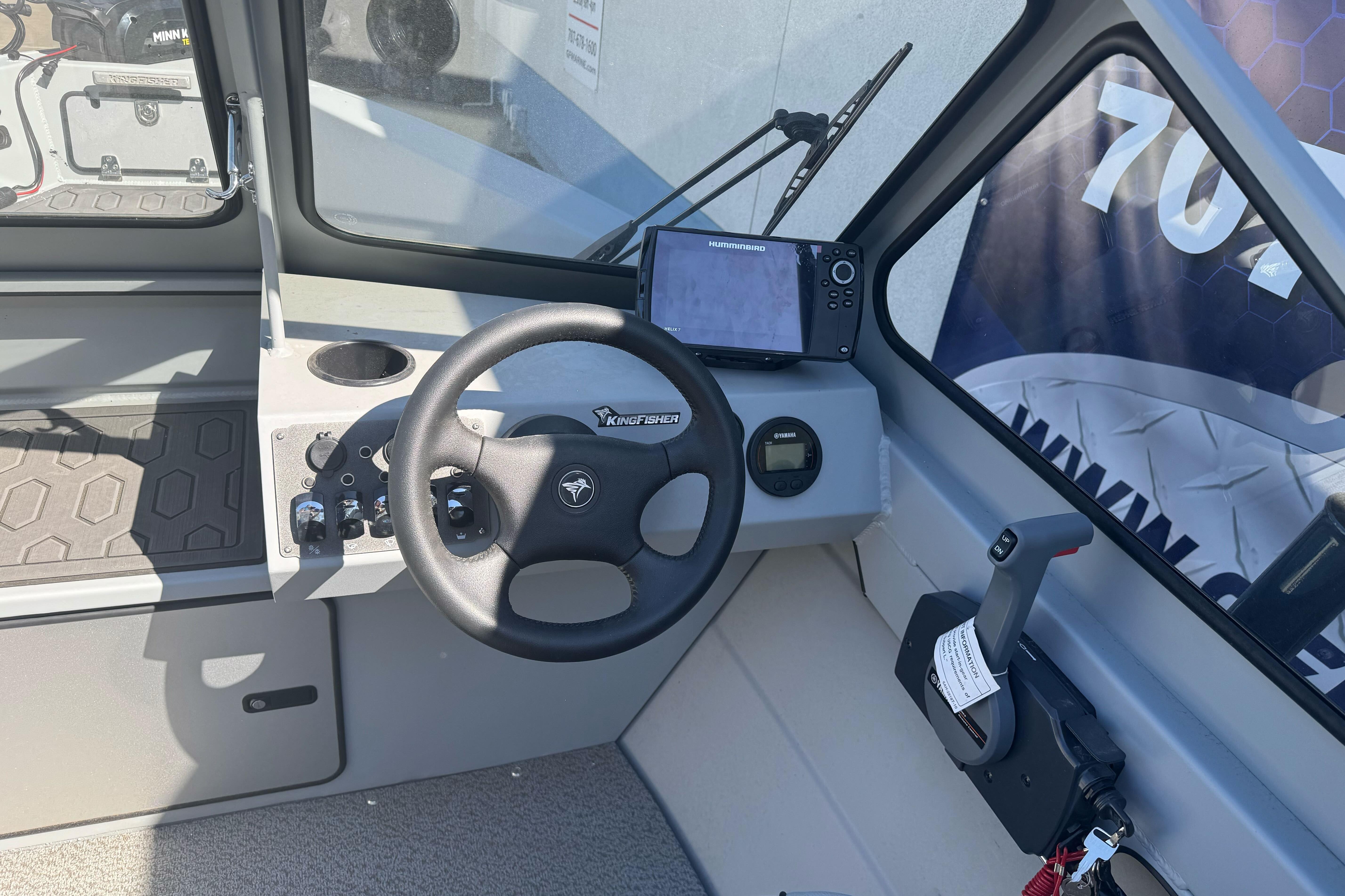 Interior of 2026 KingFisher 16 Falcon boat with steering wheel and navigation system.