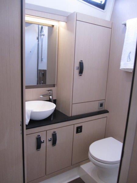 Modern bathroom in 2024 Jeanneau 60 yacht with sleek fixtures and ample storage.