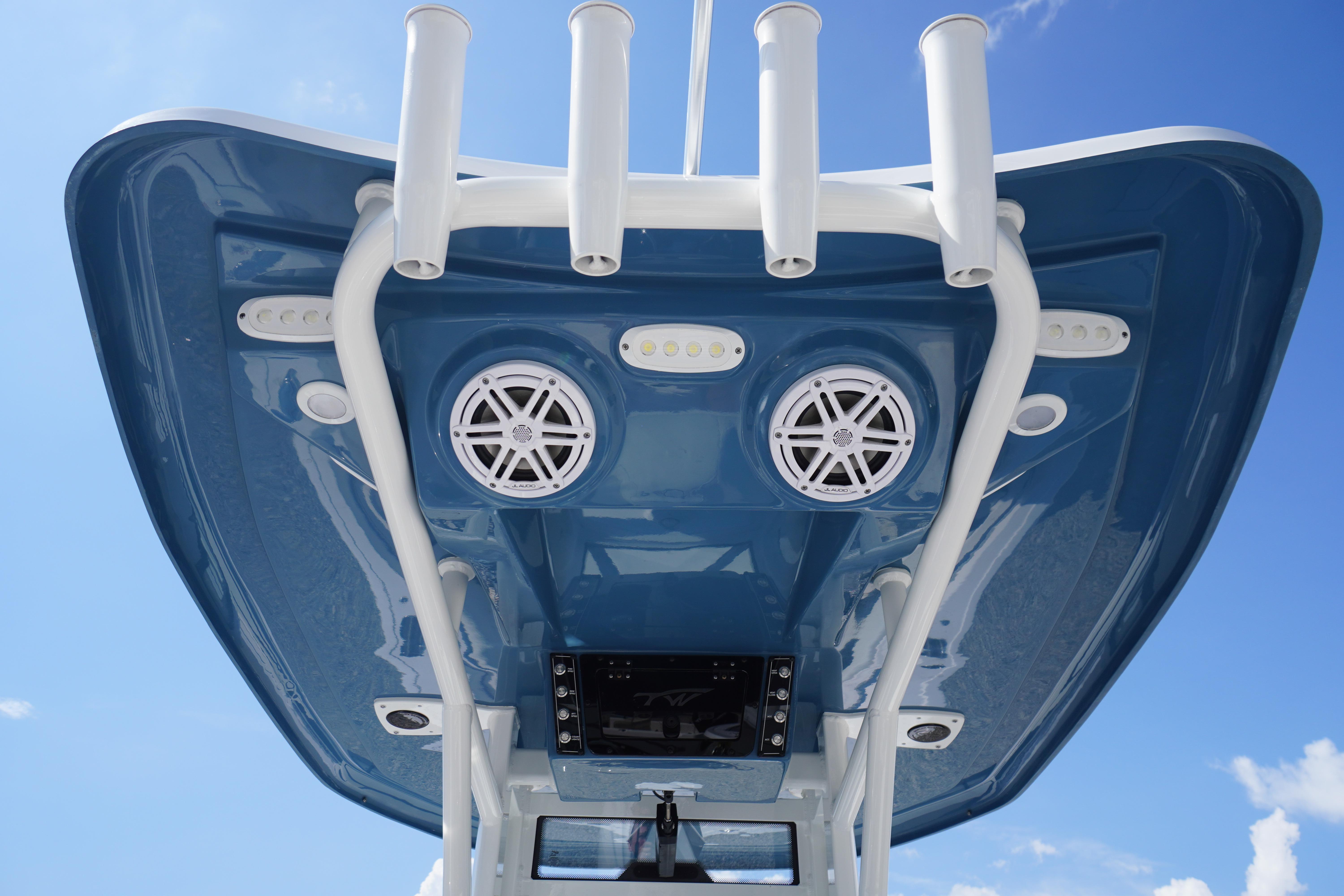 2025 Tidewater 232 SS boat roof with speakers and rod holders against blue sky.