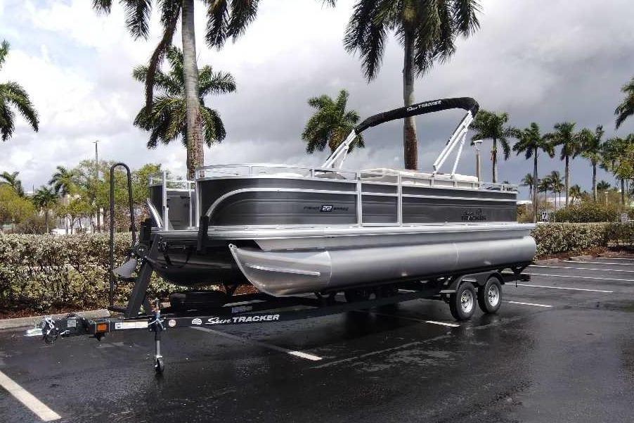 2026 Sun Tracker Fishin' Barge 22 DLX pontoon boat on trailer.