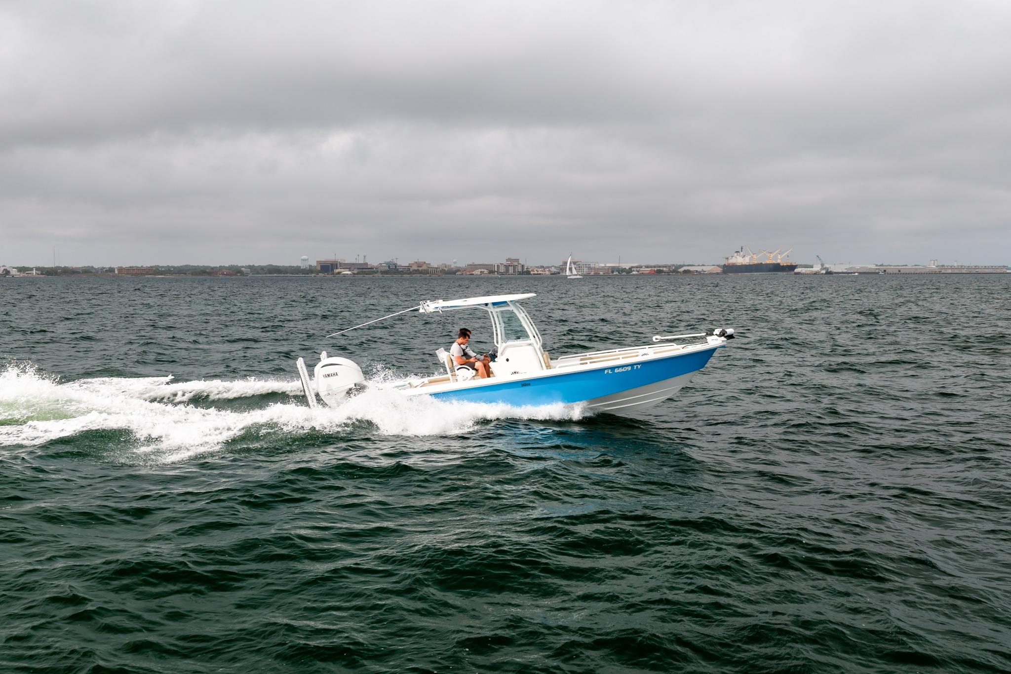 2023 Everglades 243 Center Console boat cruising on open water under cloudy skies.