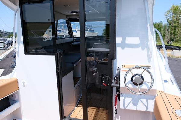 2023 Makaira Gen3 800 boat interior with steering wheel and seating area.