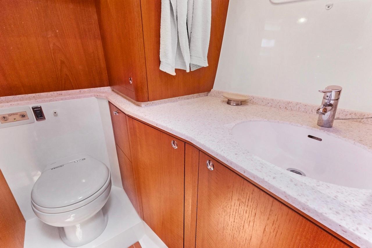 Luxurious bathroom in 2011 Southerly 57 RS yacht with wooden cabinetry and modern fixtures.