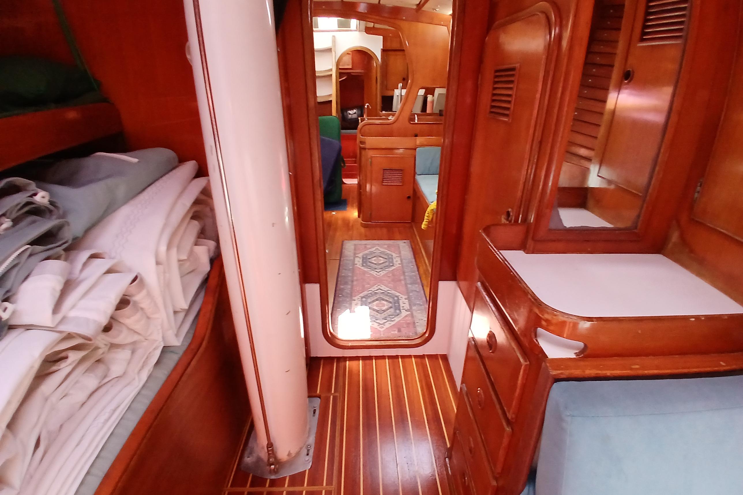 Interior of 1981 SKYE 51 sailboat with wooden cabinetry and neatly folded linens.