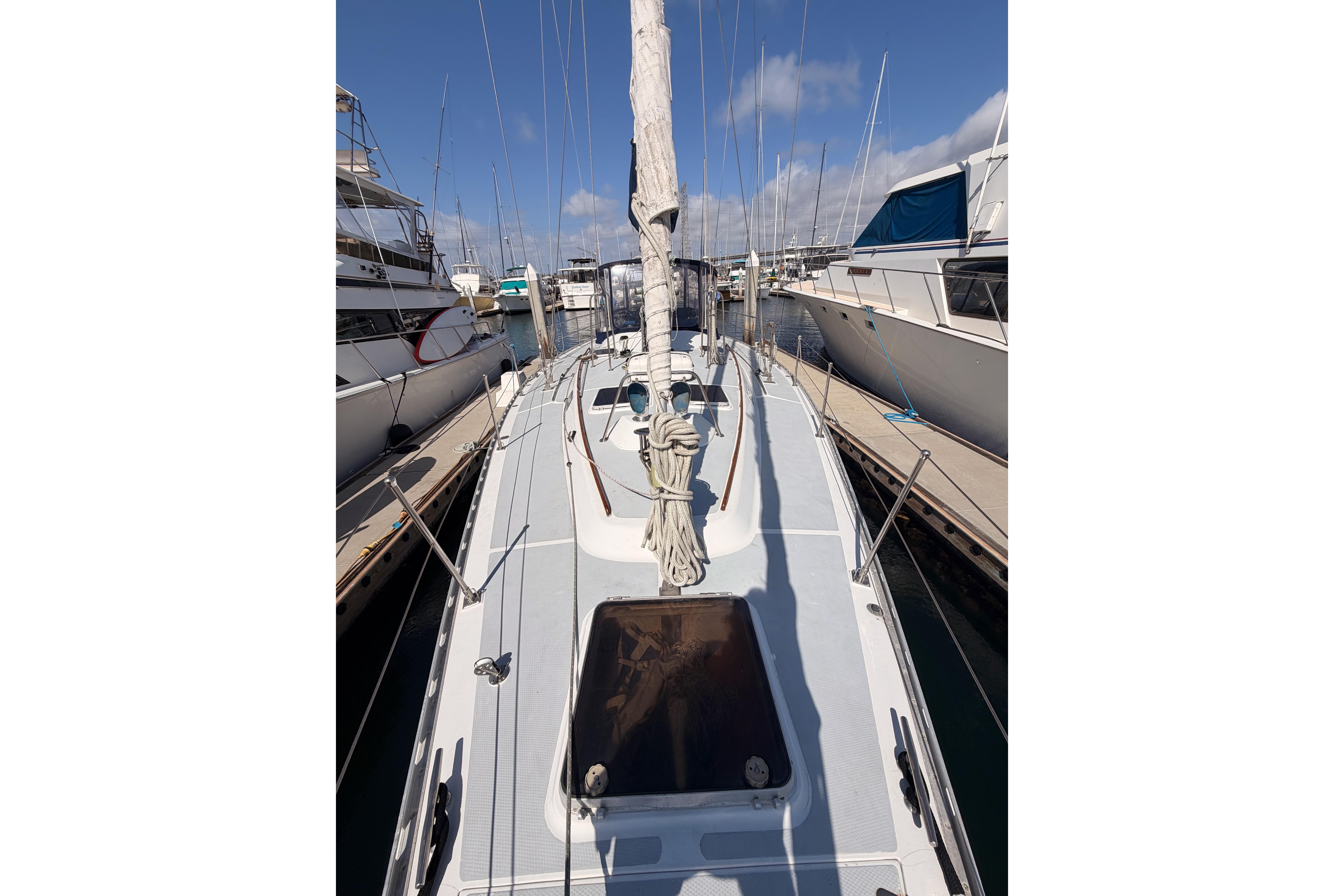 Sailboat docked at marina, Hylas 51 model, 1991, with clear blue sky.