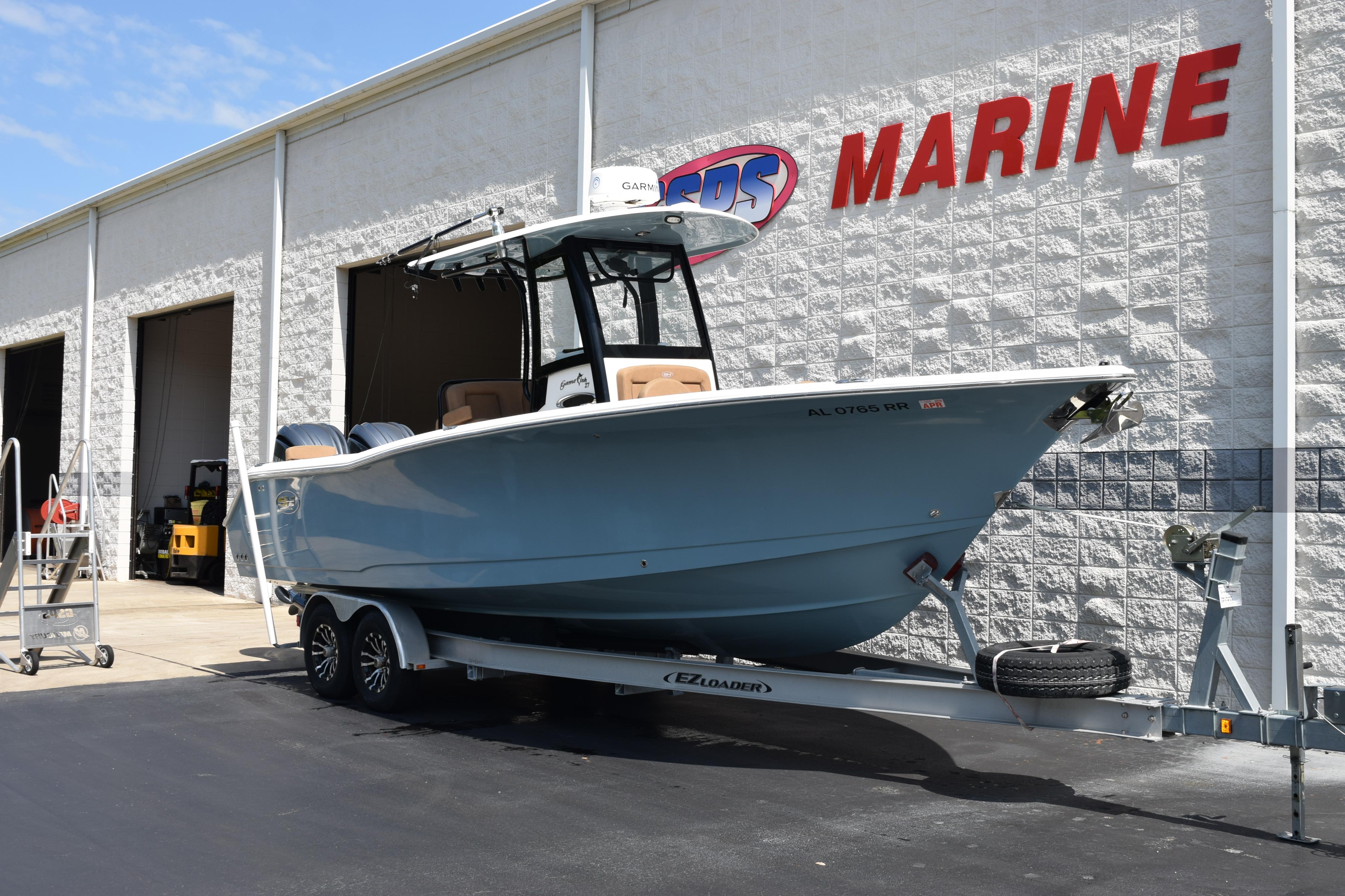 2022 Sea Hunt Gamefish 27 boat on trailer outside marine shop.