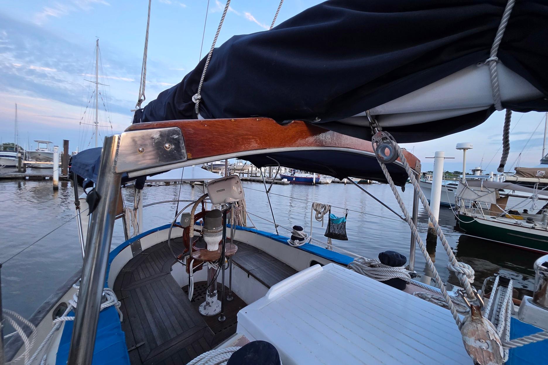 1982 Tayana 37 sailboat docked at marina, featuring wooden deck and rigging.