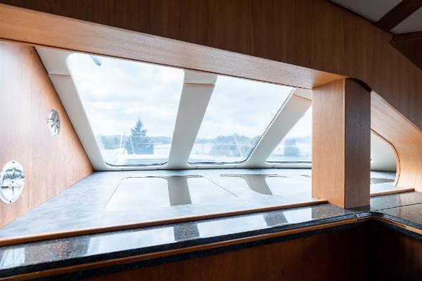Interior view of 2025 Shuttleworth 52 AeroRig yacht, featuring sleek wooden design and large windows.