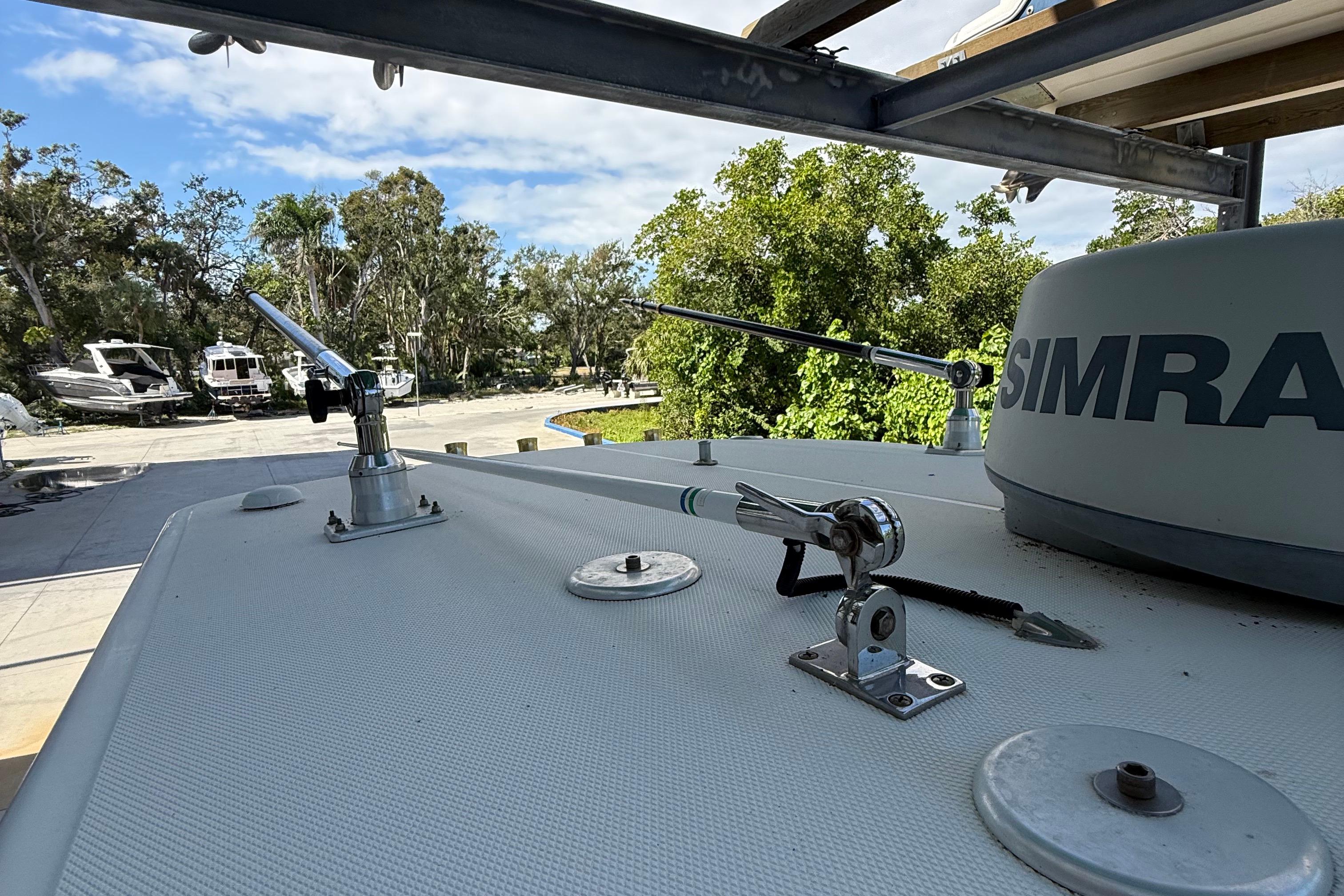 2008 Century 2901 Center Console boat with Simrad equipment, docked near trees and other boats.
