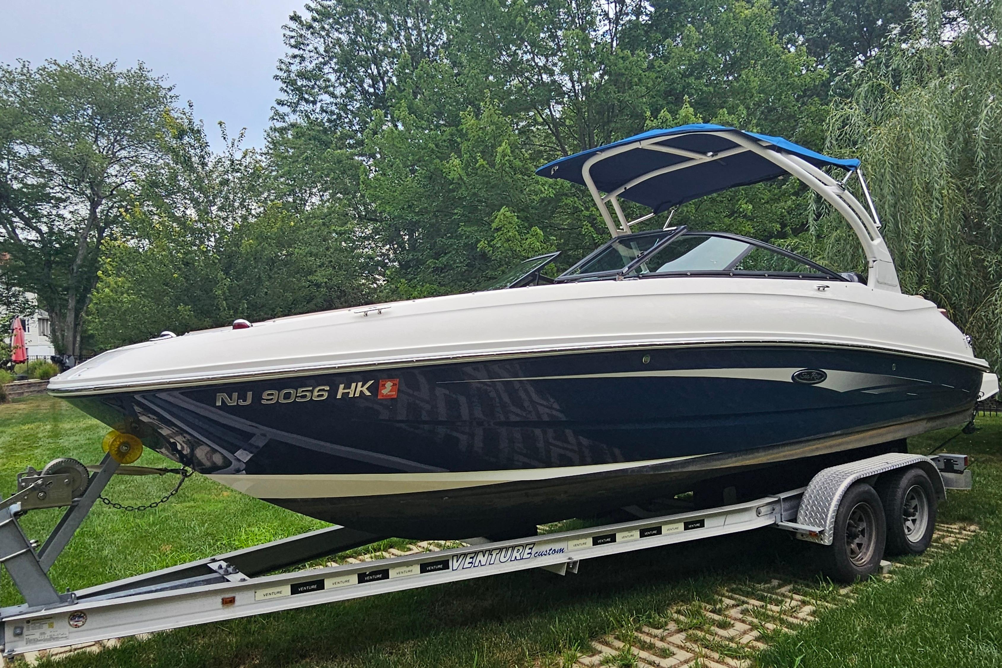 2017 Sea Ray SDX 240 Outboard boat on trailer, parked on grass.
