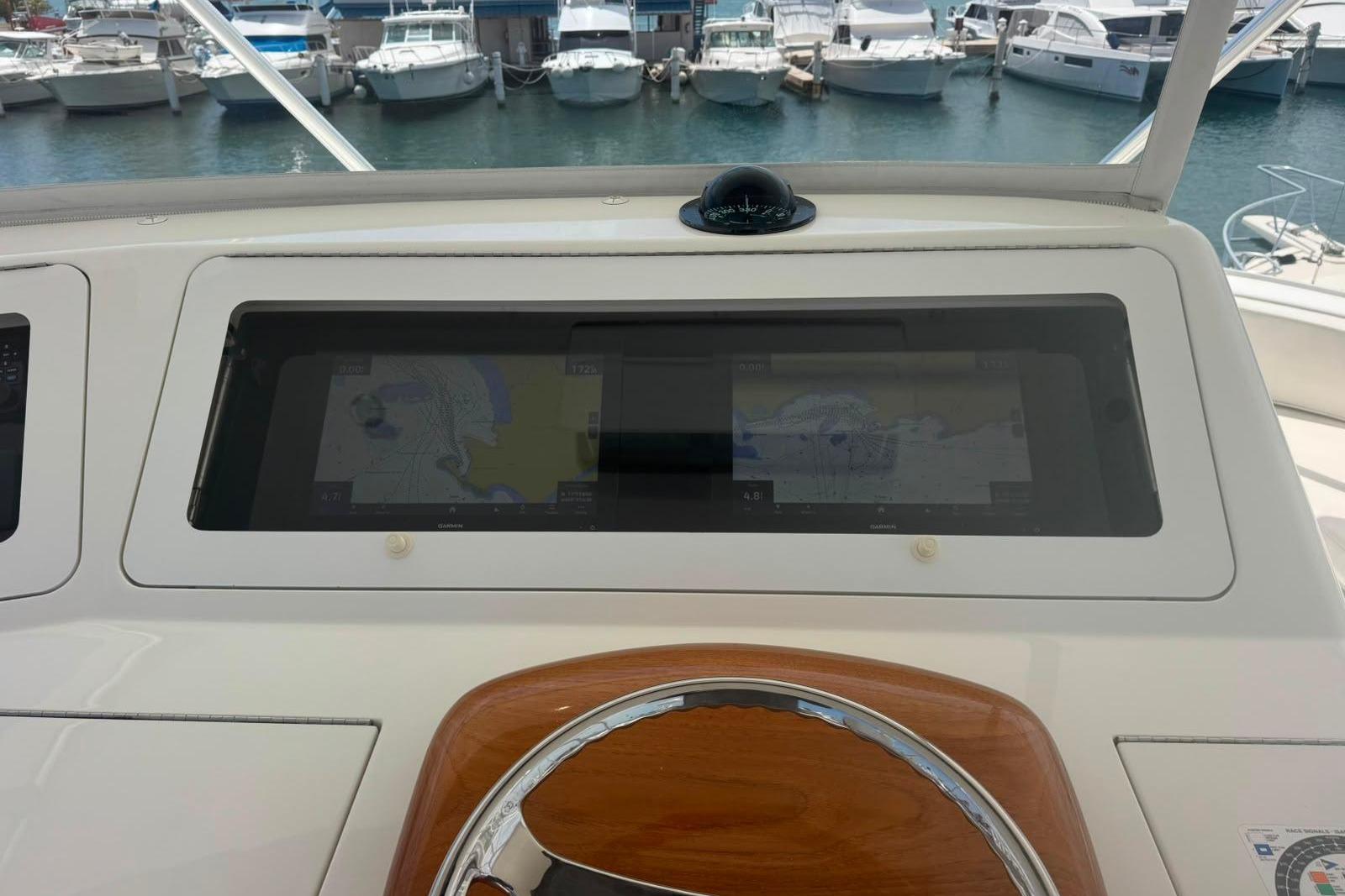 Helm of 2012 Viking 50 Convertible yacht with navigation screens and compass.