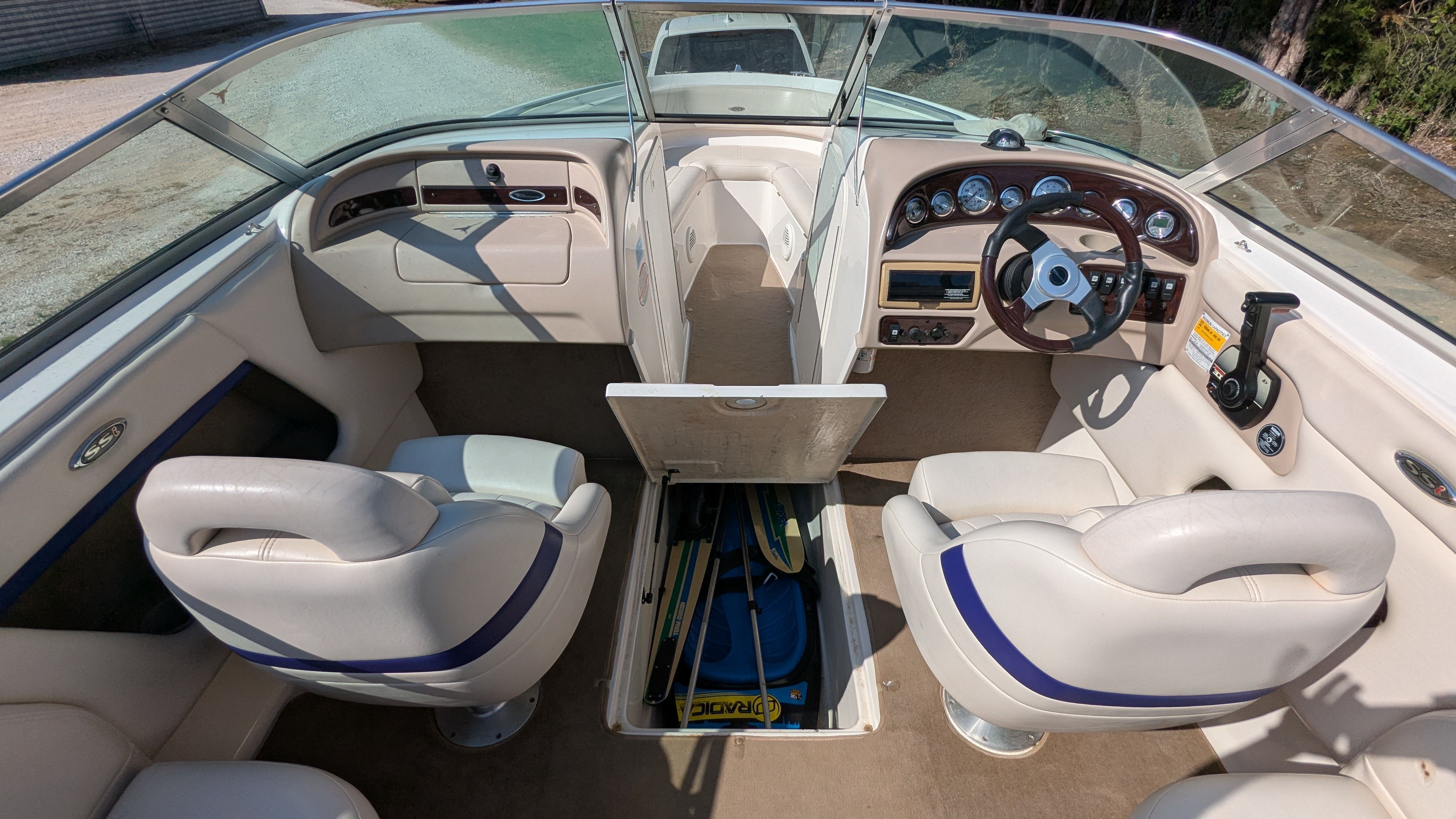 Interior of a 2000 Chaparral 240 SSi with white seats and a helm station.
