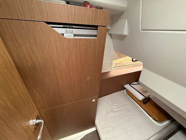 Interior of the Jeanneau NC 1095 featuring wood cabinetry and a single bed.