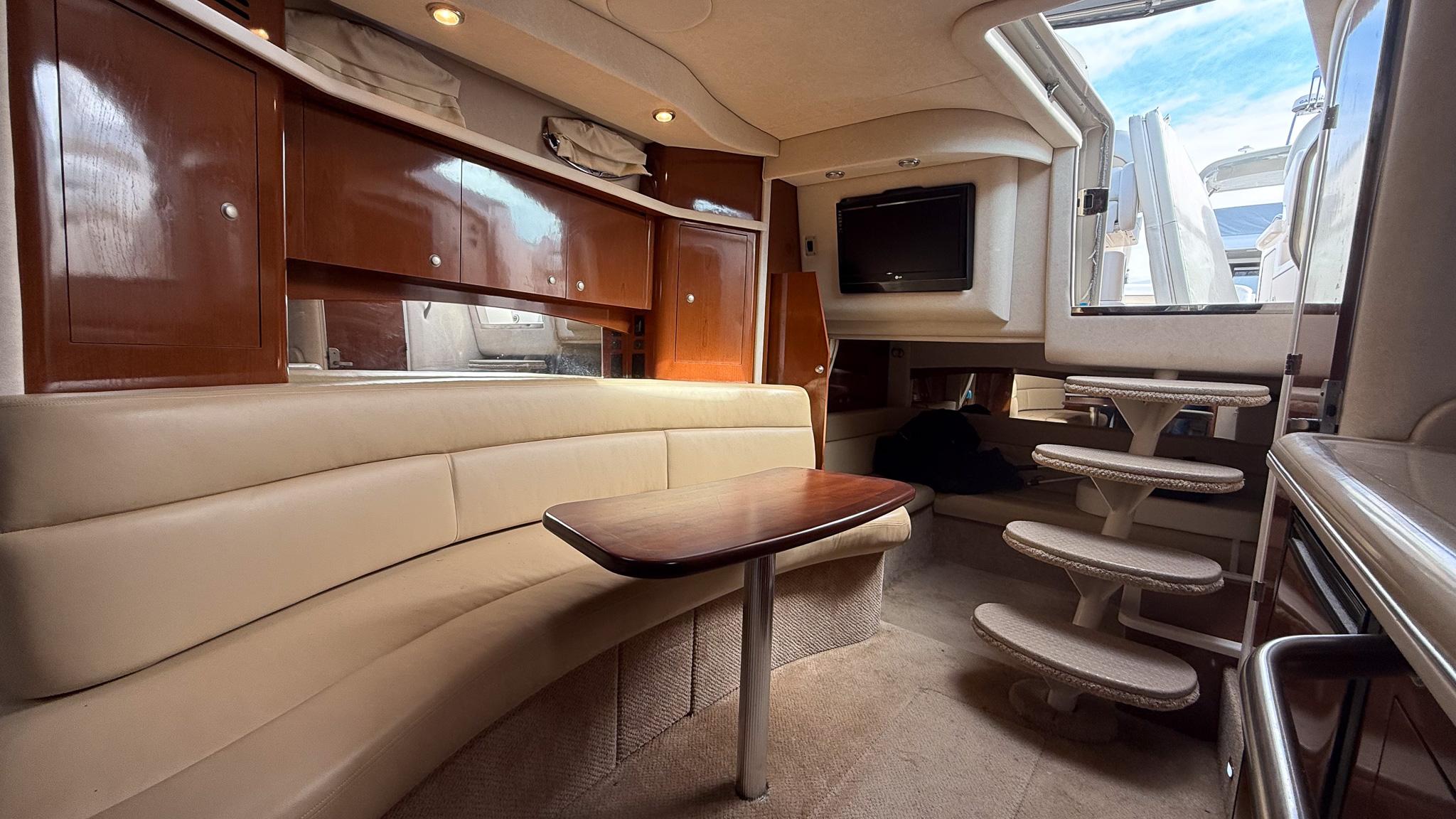 2008 Sea Ray 340 Sundancer interior with plush seating, wooden cabinetry, and a compact dining area.