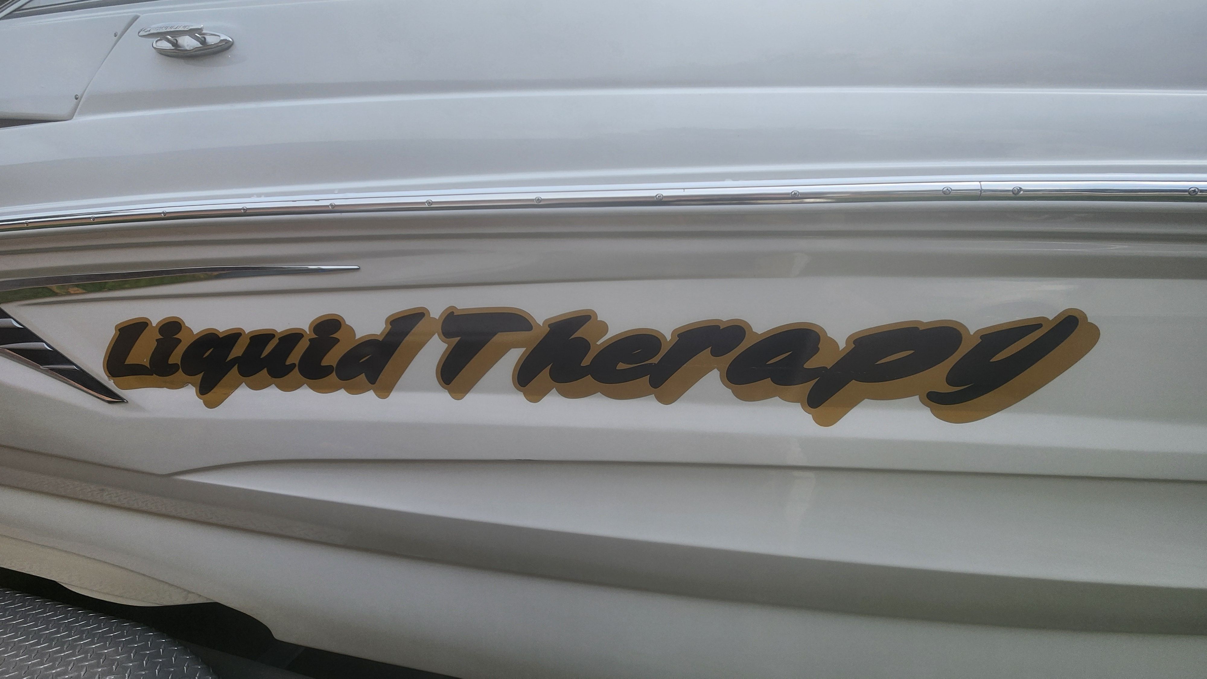 The words "Liquid Therapy" are displayed on the side of a Crownline Eclipse E235 XS boat.