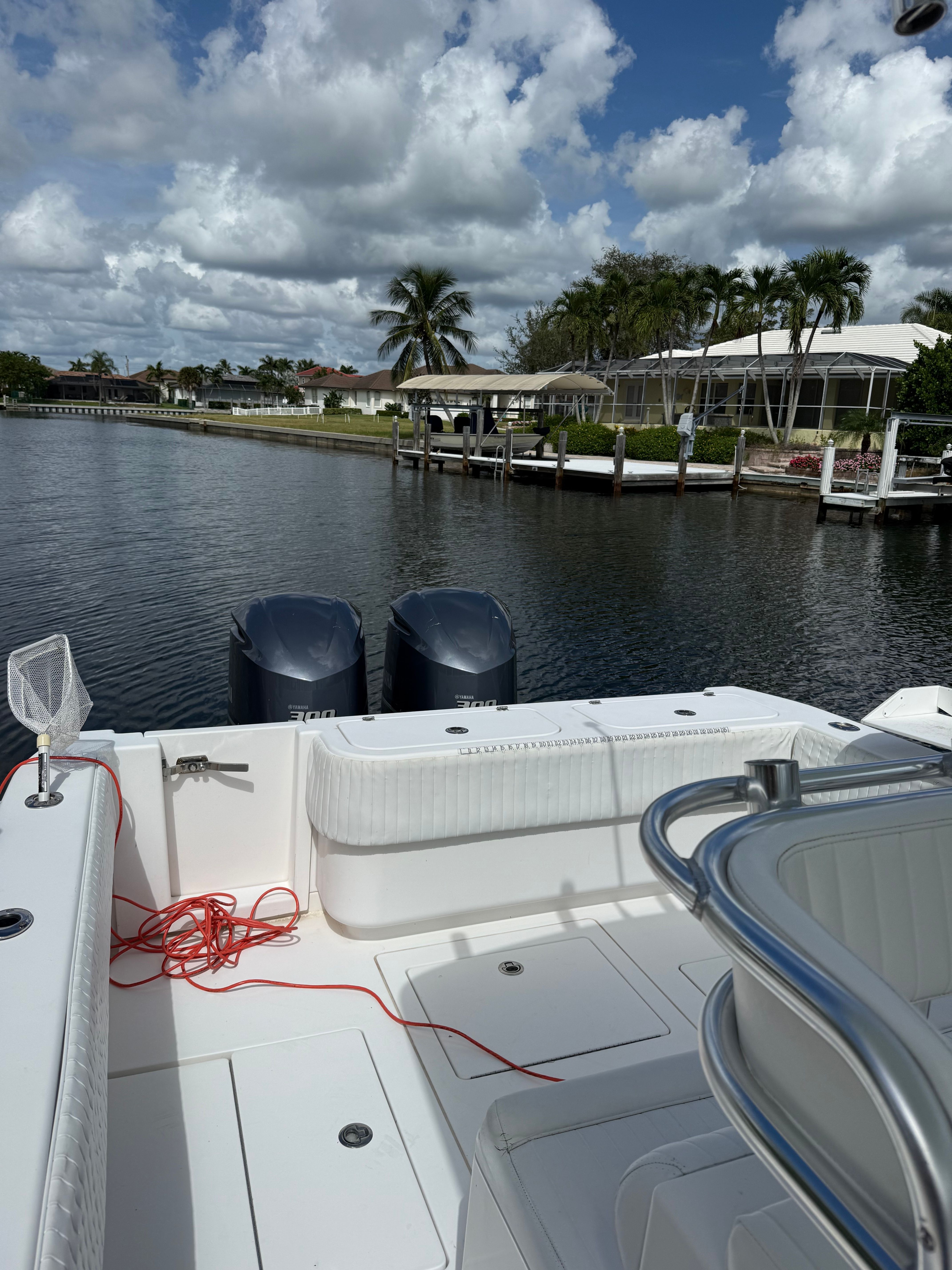2012 Contender 32 ST boat by the water with palm trees in background.