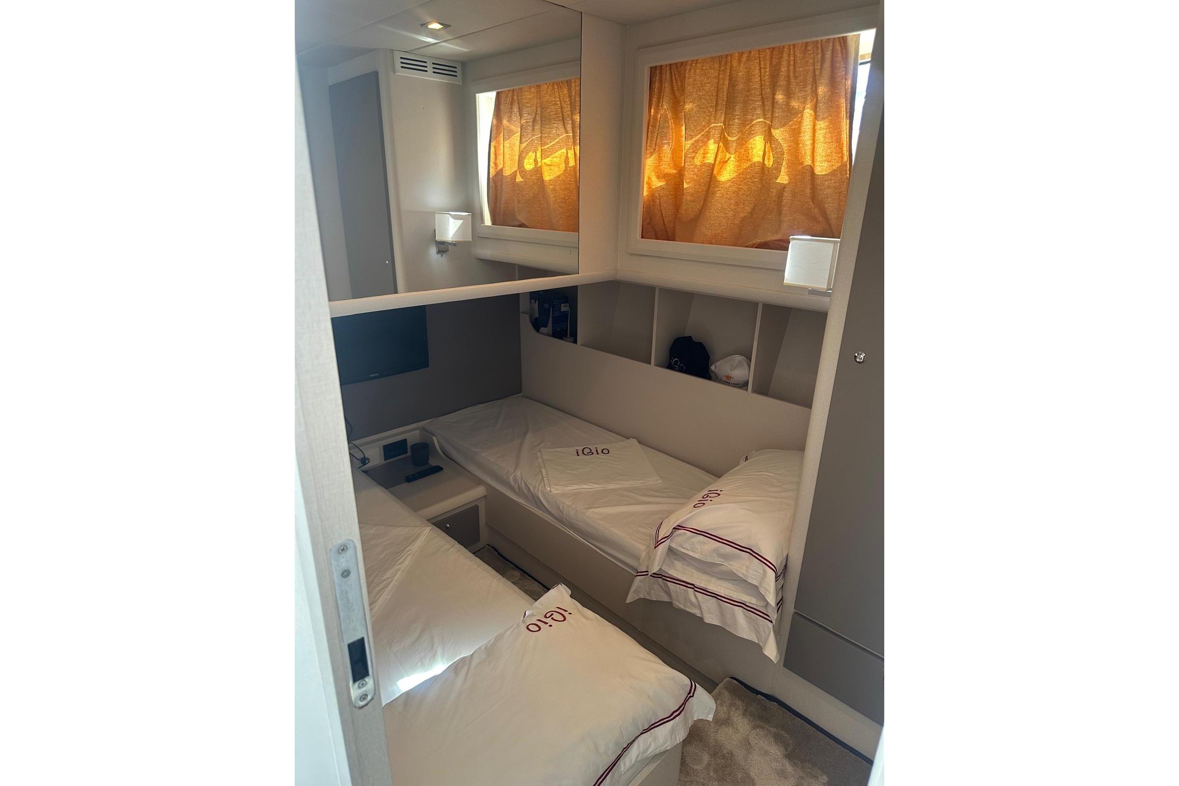 Cozy cabin interior of 2005 Mochi Dolphin 51 yacht with twin beds and warm lighting.