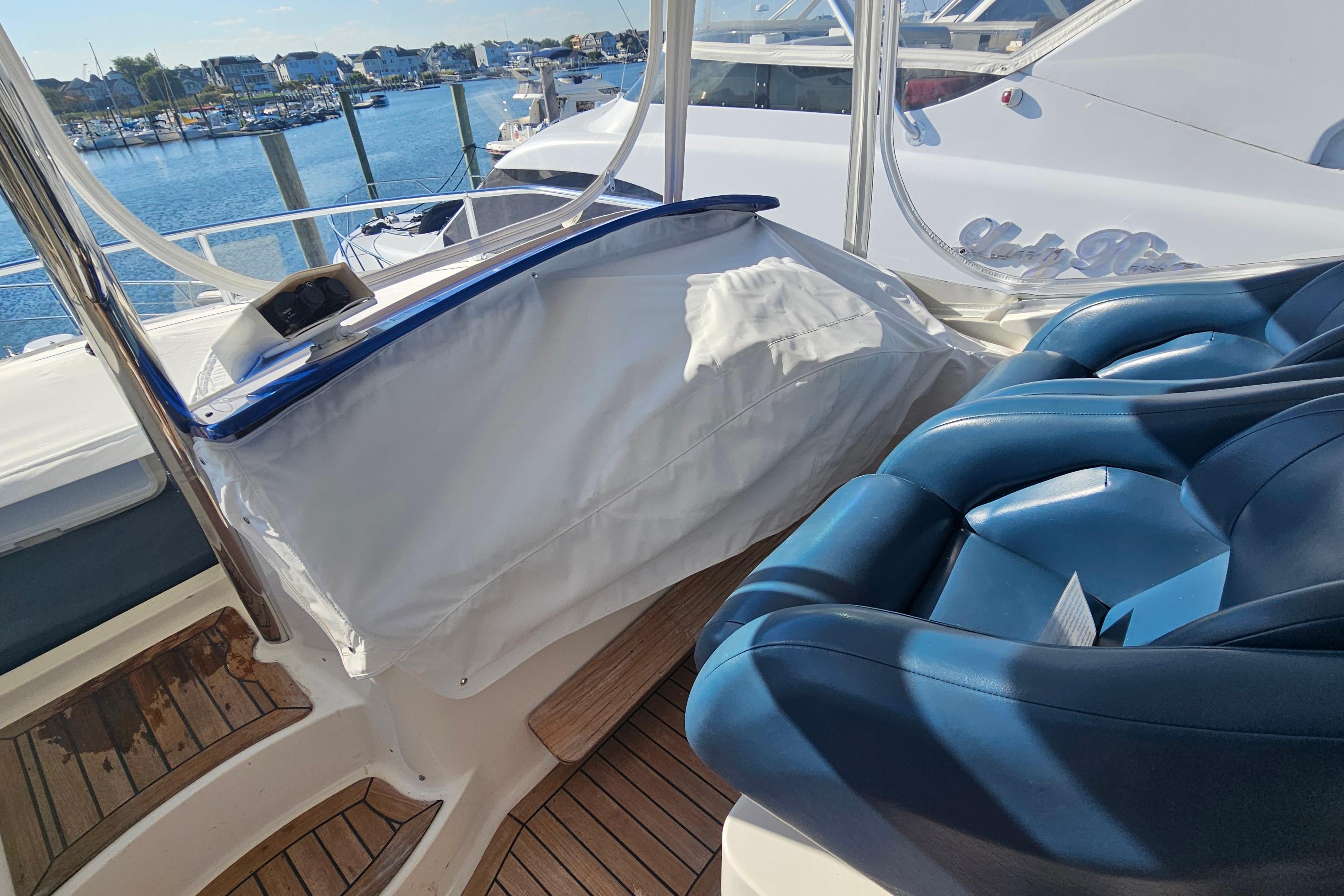 Flybridge of 2005 Neptunus 56 yacht with blue seating and marina view.