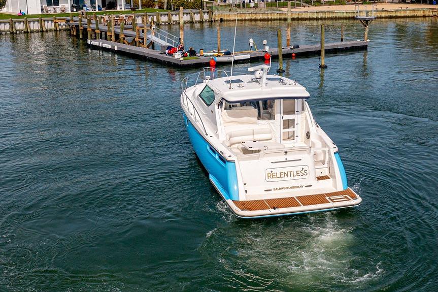 2006 Tiara Yachts 4300 Sovran cruising near a dock in calm waters.