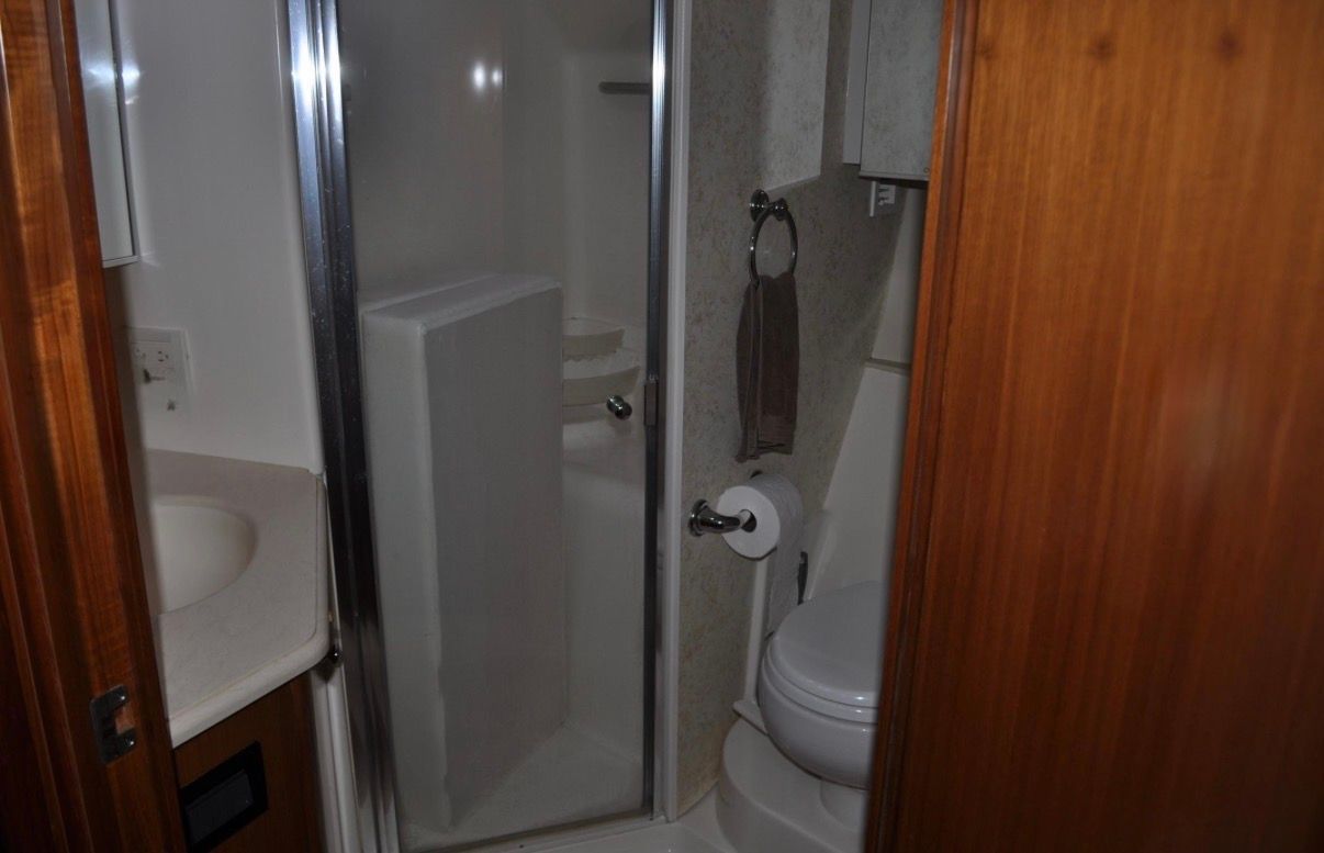 Bathroom with shower, toilet, and sink inside a yacht.