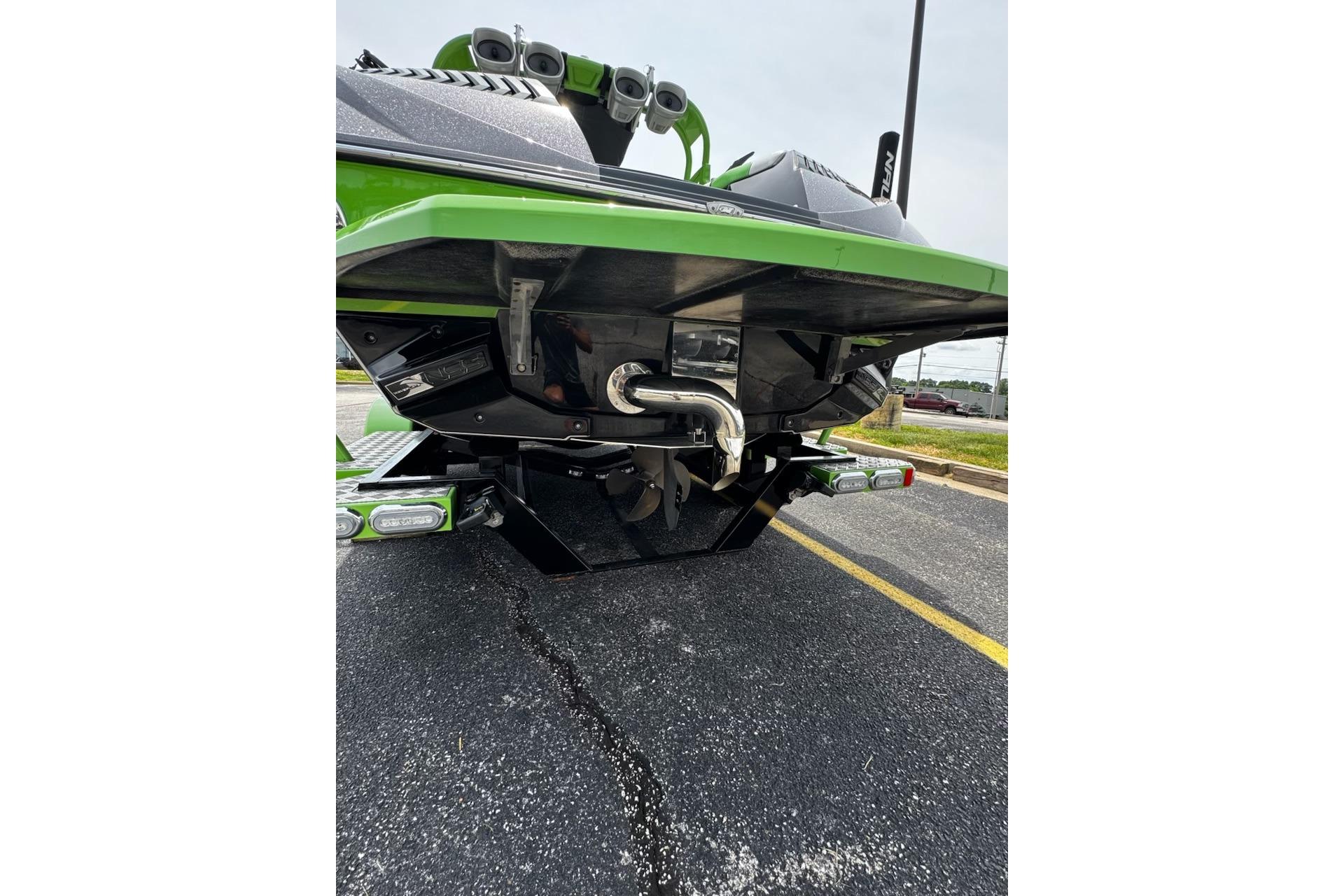 2014 Nautique Super Air Nautique G21 boat rear view, showcasing green hull and exhaust system.